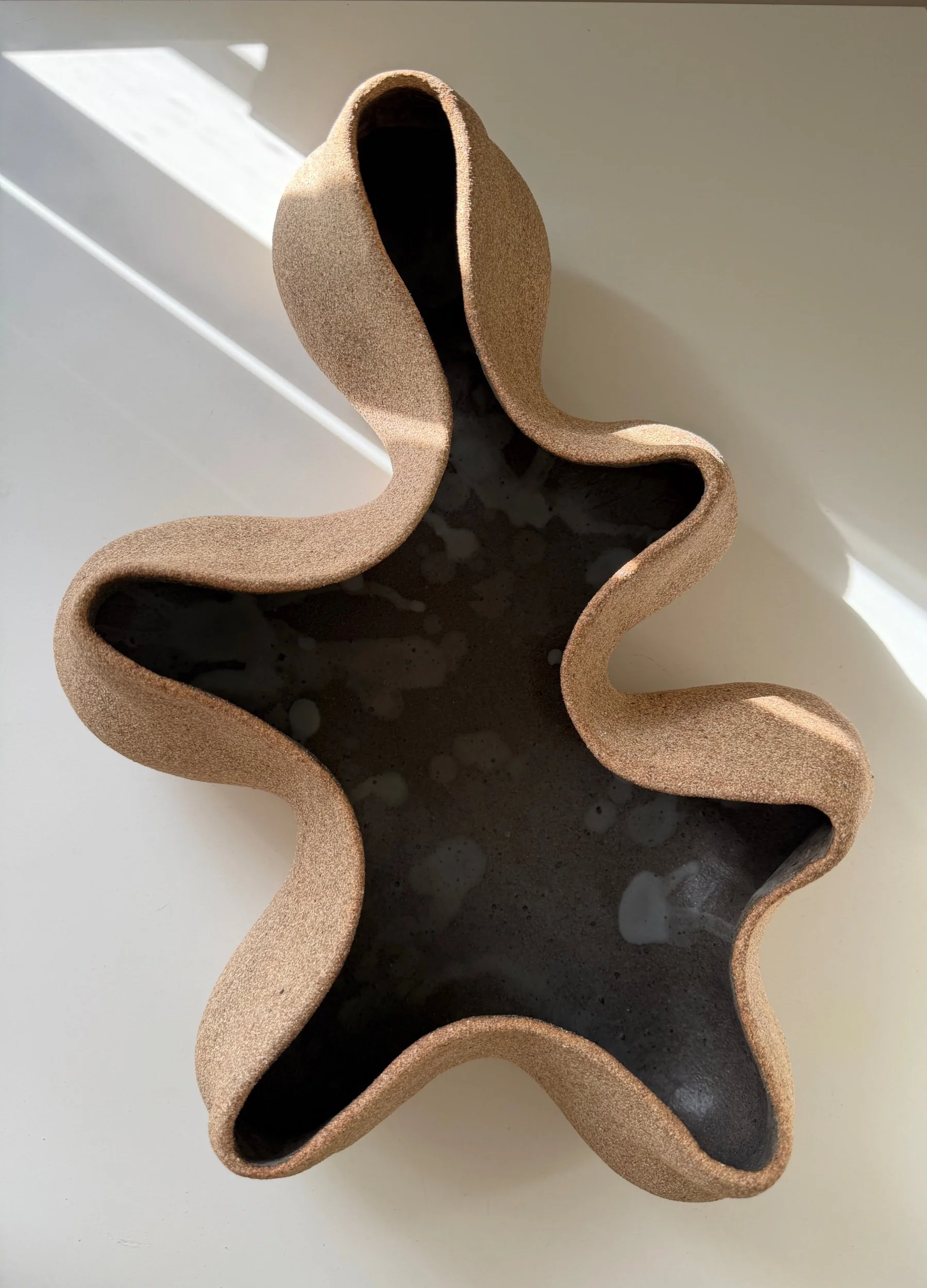 Organic Form Sculpture No. 8 by Anna Shipulina — a hand-built ceramic sculpture with unglazed stoneware exterior and a dark glazed interior, undulating organic edges.