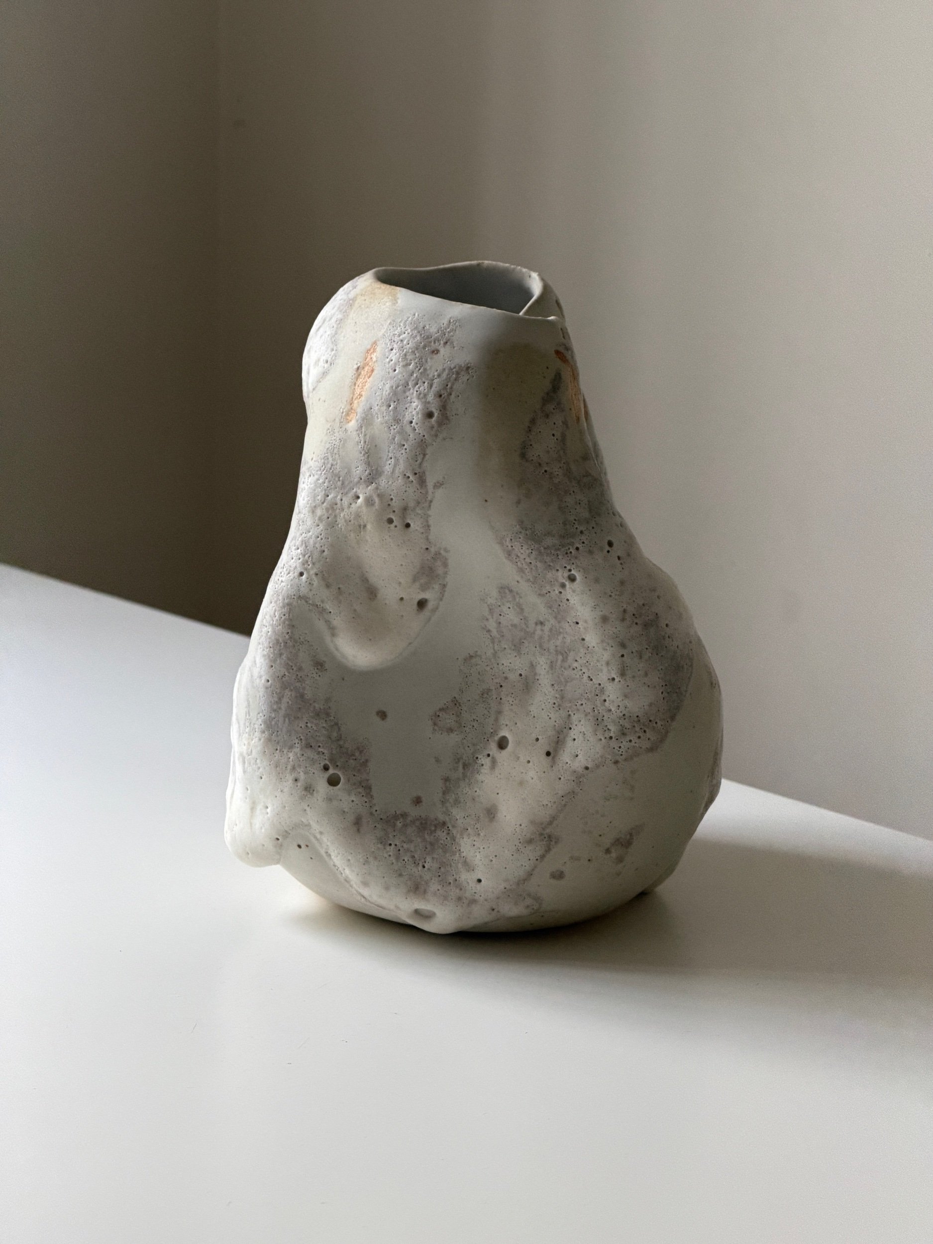Textured handmade stoneware ceramic vase with organic sculptural form in neutral tones