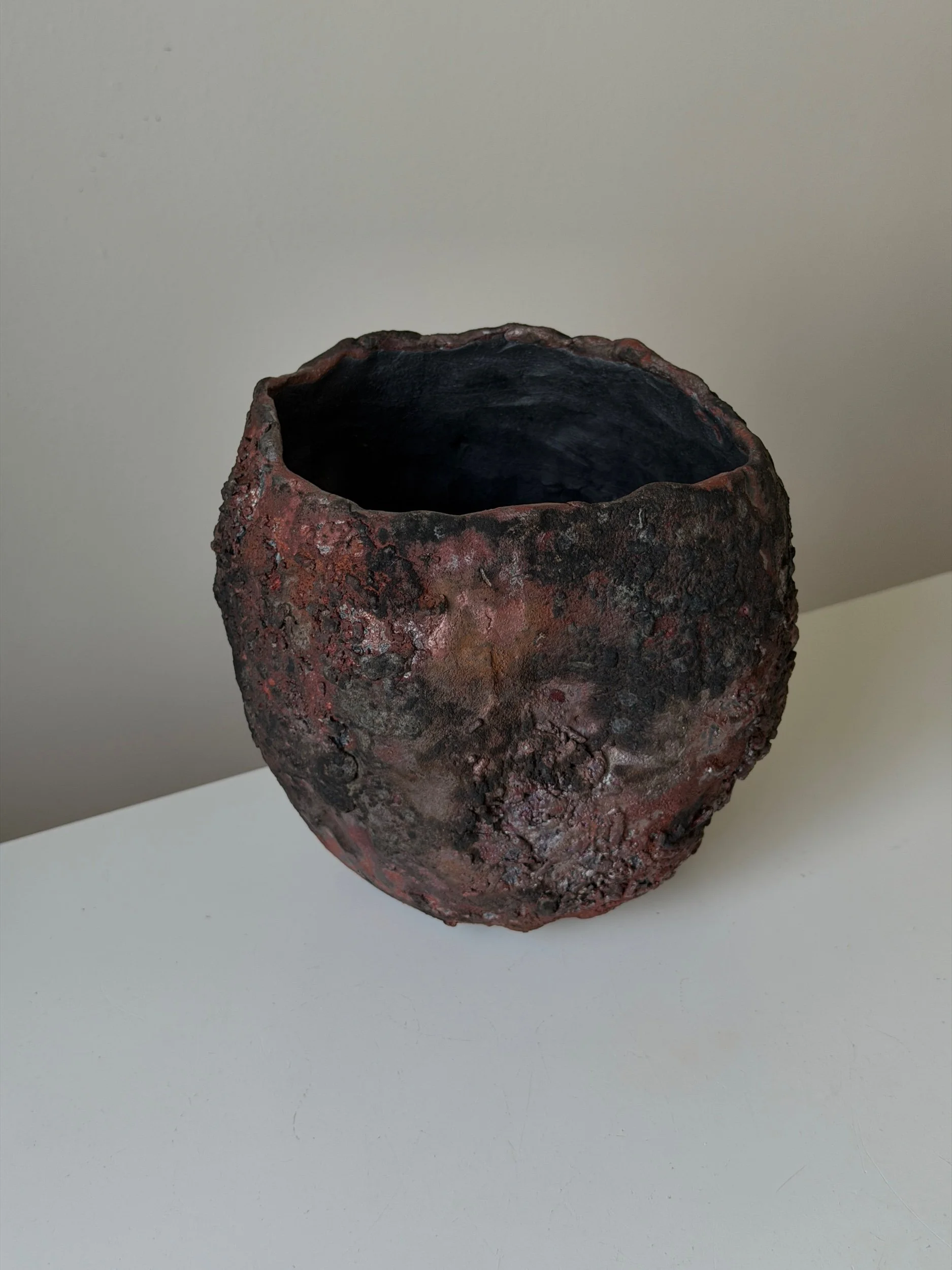 Raku fired ceramic vase in dark tones