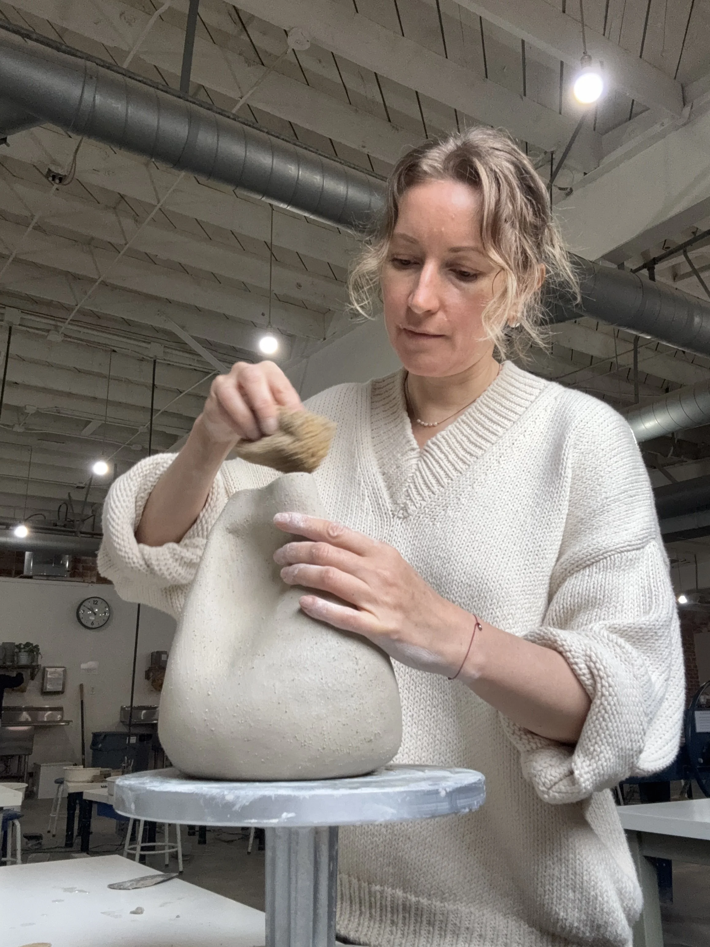 Ceramic artist Anna Shipulina handbuilding a stoneware vessel in her Los Angeles studio