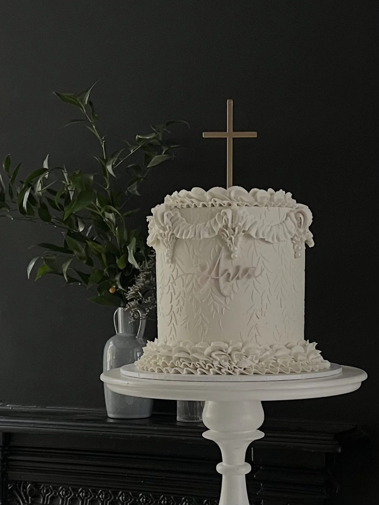 elegant christening cake with cross topper and vintage piping. created at our altrincham kitchen and delivered to london.