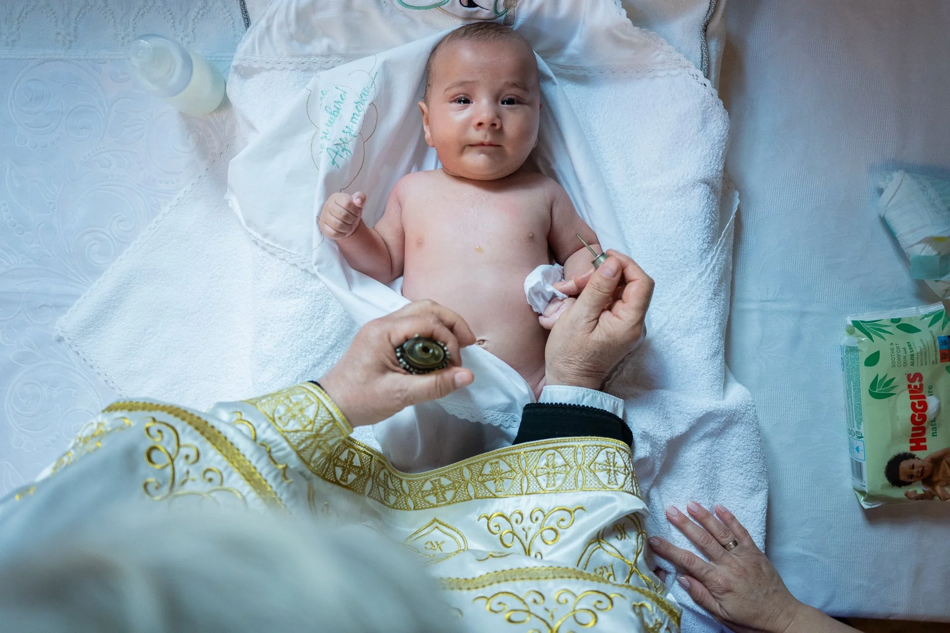 baietelul botezat este miruns de preot