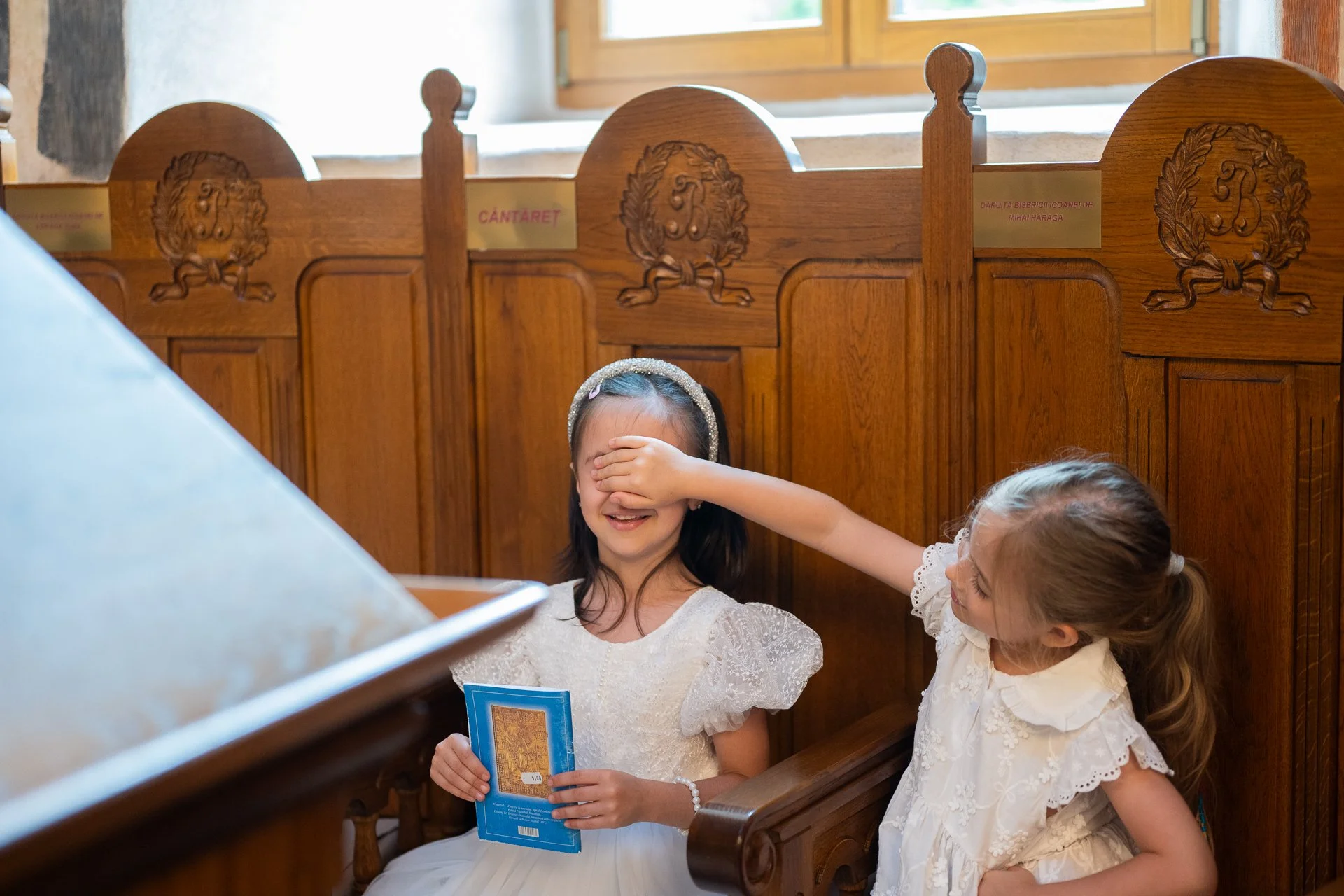 o fetita ii pune mana la ochi alteia in joaca