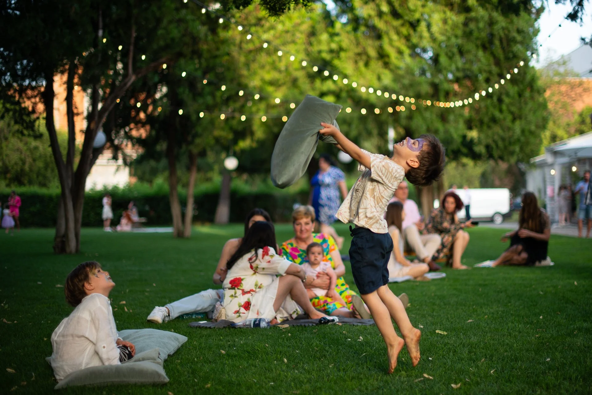 un baietel sare in sus cu o perna