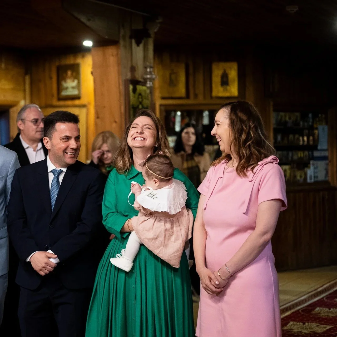 mama si tata saruta fiecare cate un obraz al bebelusului la pregatirile pentru botez