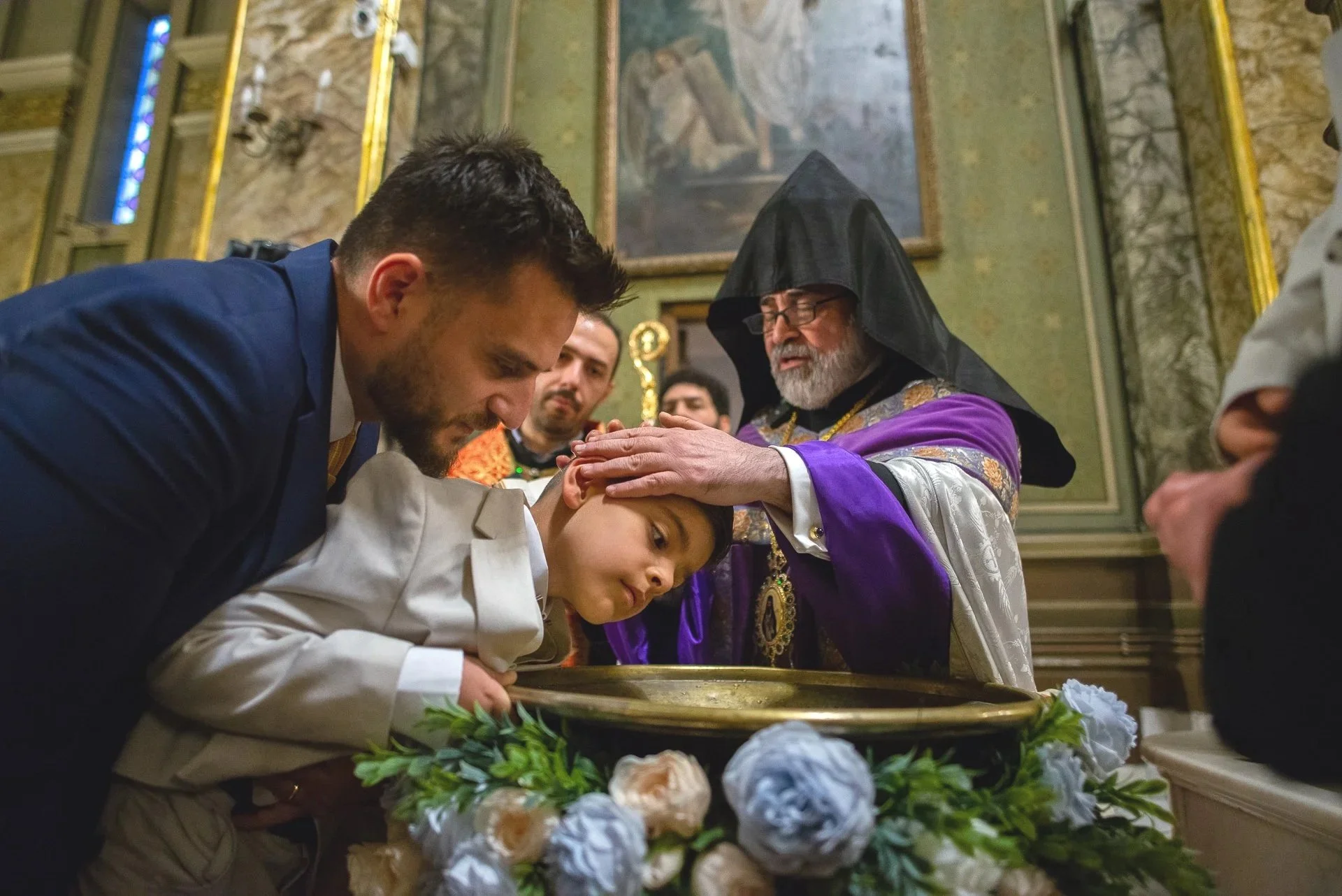 nasul in tine deasupra cristenitei pe baiatul care este botezat de preot in cadrul unei slujbe armenesti