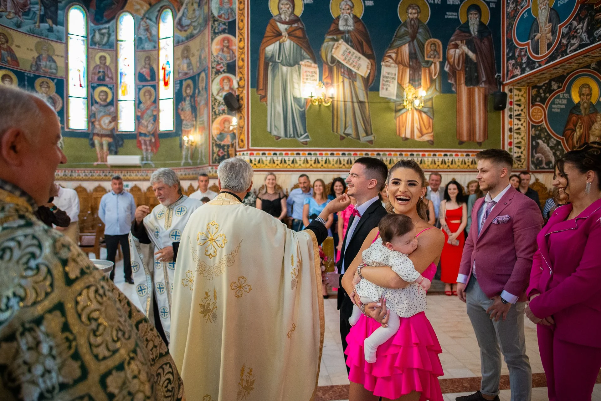 nasa rade cu bebelusul in brate in timpul slujbei de botez