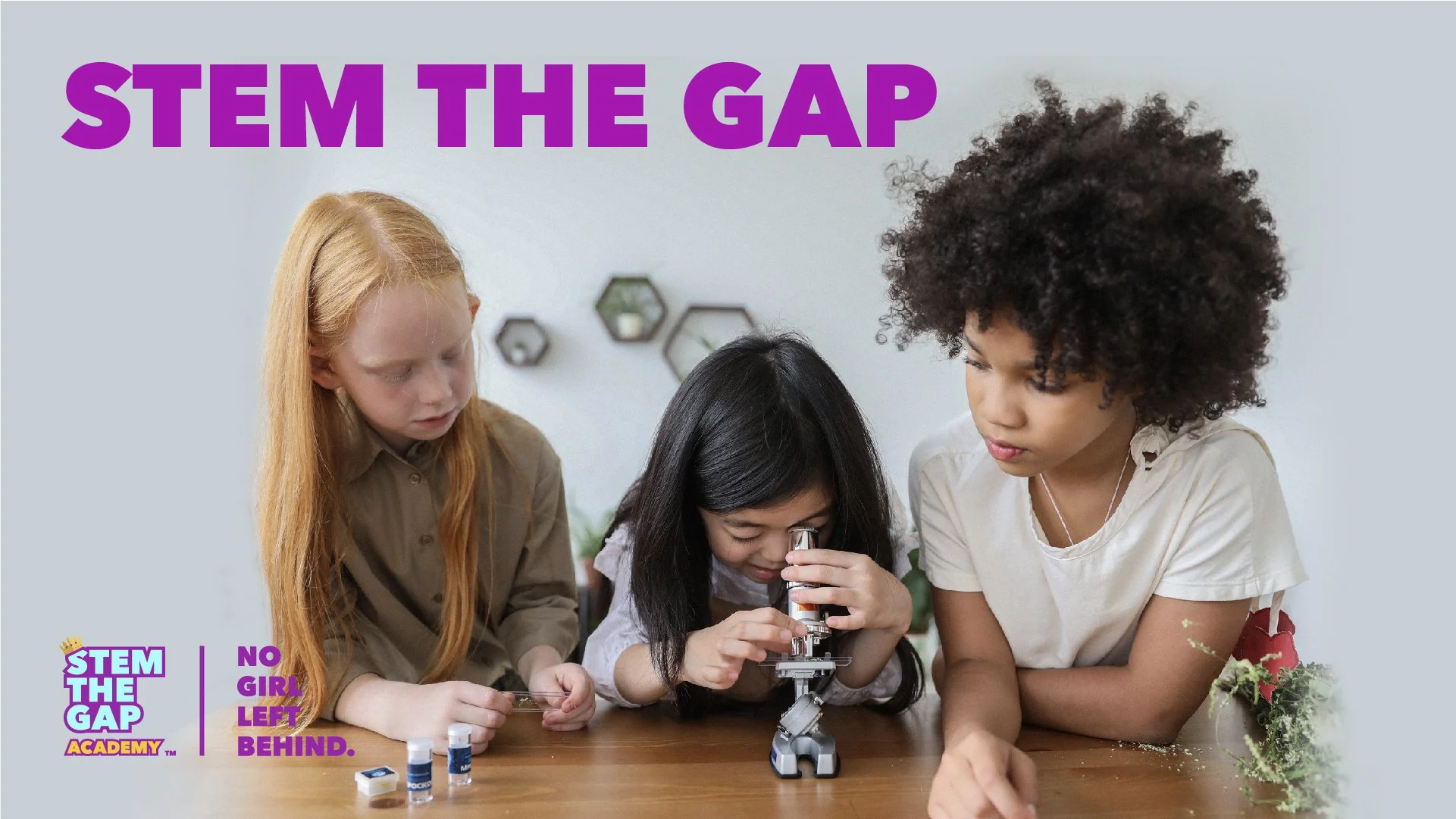 Three girls taking turns looking through a microscope during a science experiment, representing girls exploring STEM.