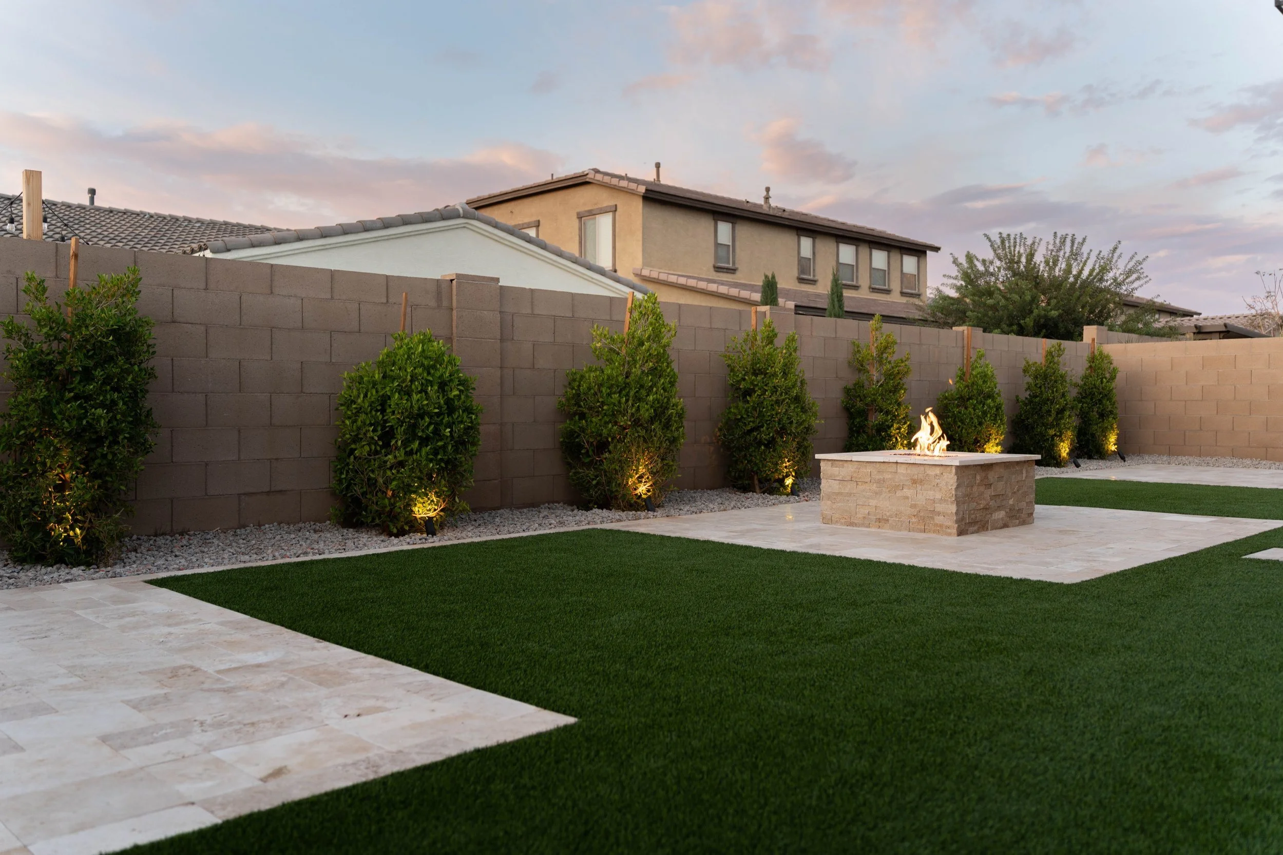 This residential backyard included tree, travertine, turf and a custom fire pit installation near Phoenix.