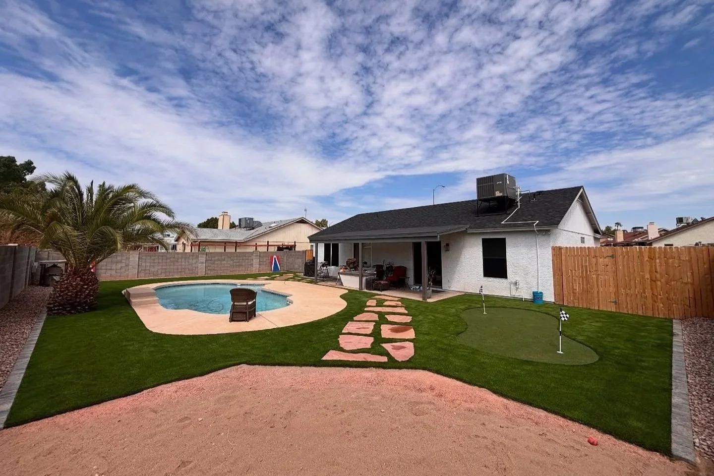 After | 3D Design into a Turf, Putting Green, Travertine, Paver Border & Tree Planting project.