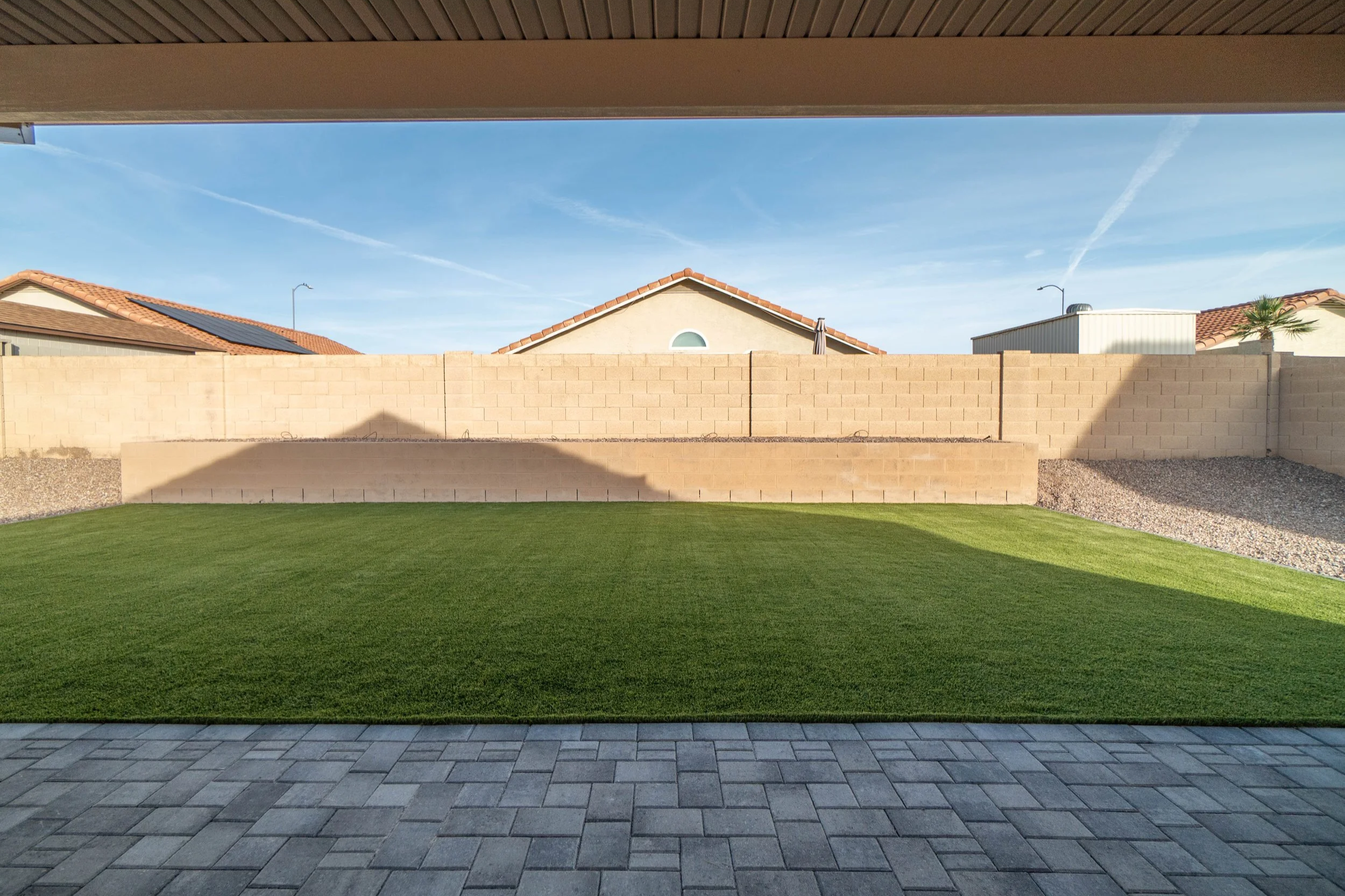 Backyard turf, pavers, rock and retaining wall installation by Better Life Landscape near Phoenix