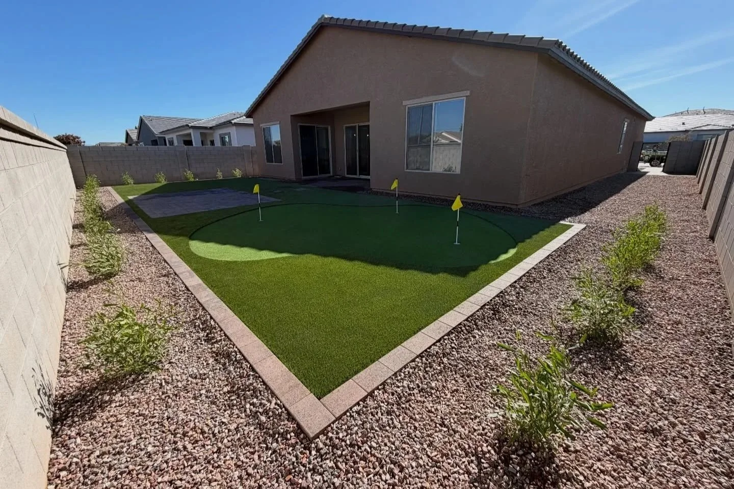 Turf putting green, tree, rocks and paver installation by Better Life Landscape & Design near Phoenix