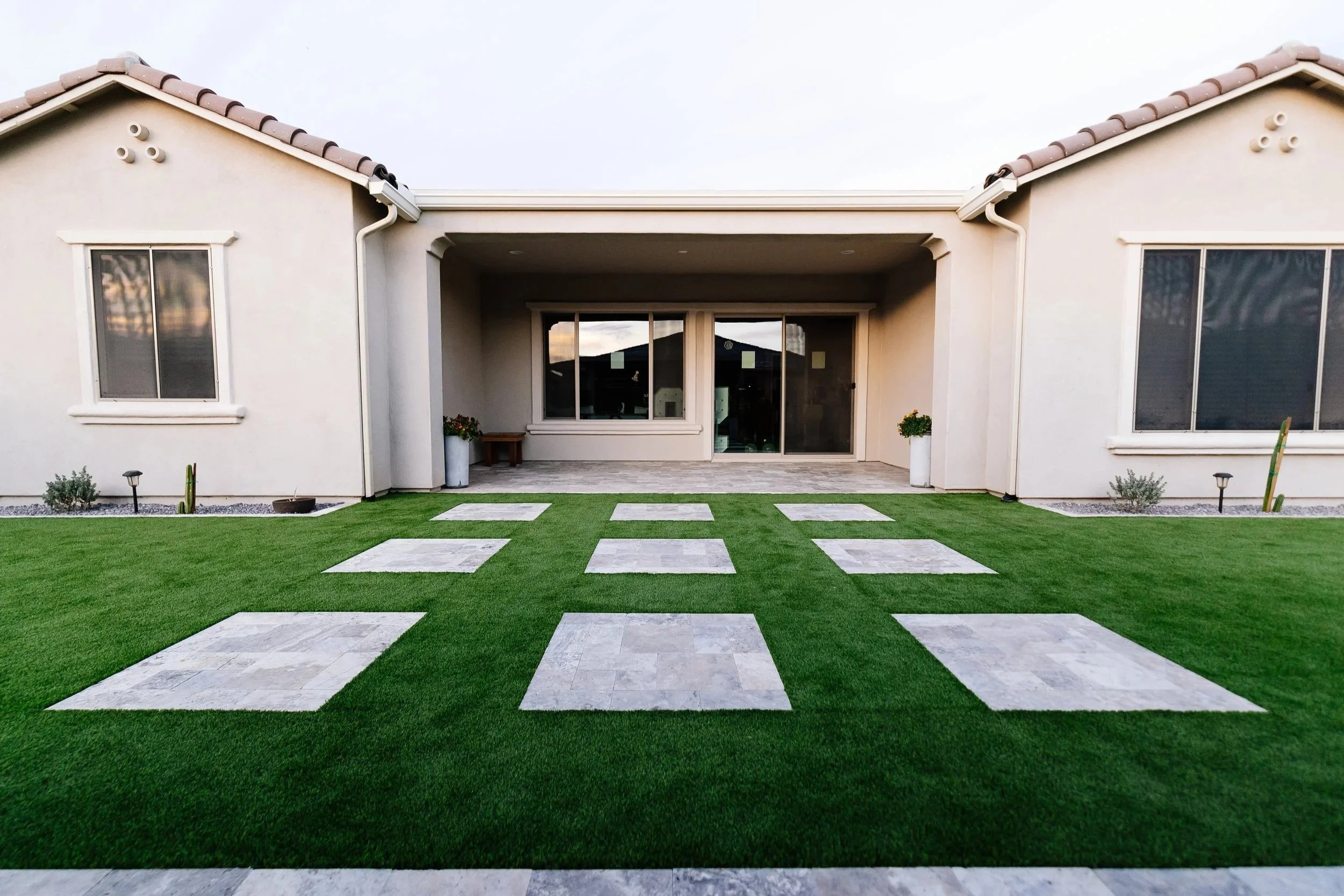Backyard turf, travertine walkway and trees installed at this new build construction home in Apache Junction at the Blossom Rock community by Better Life Landscape & Design