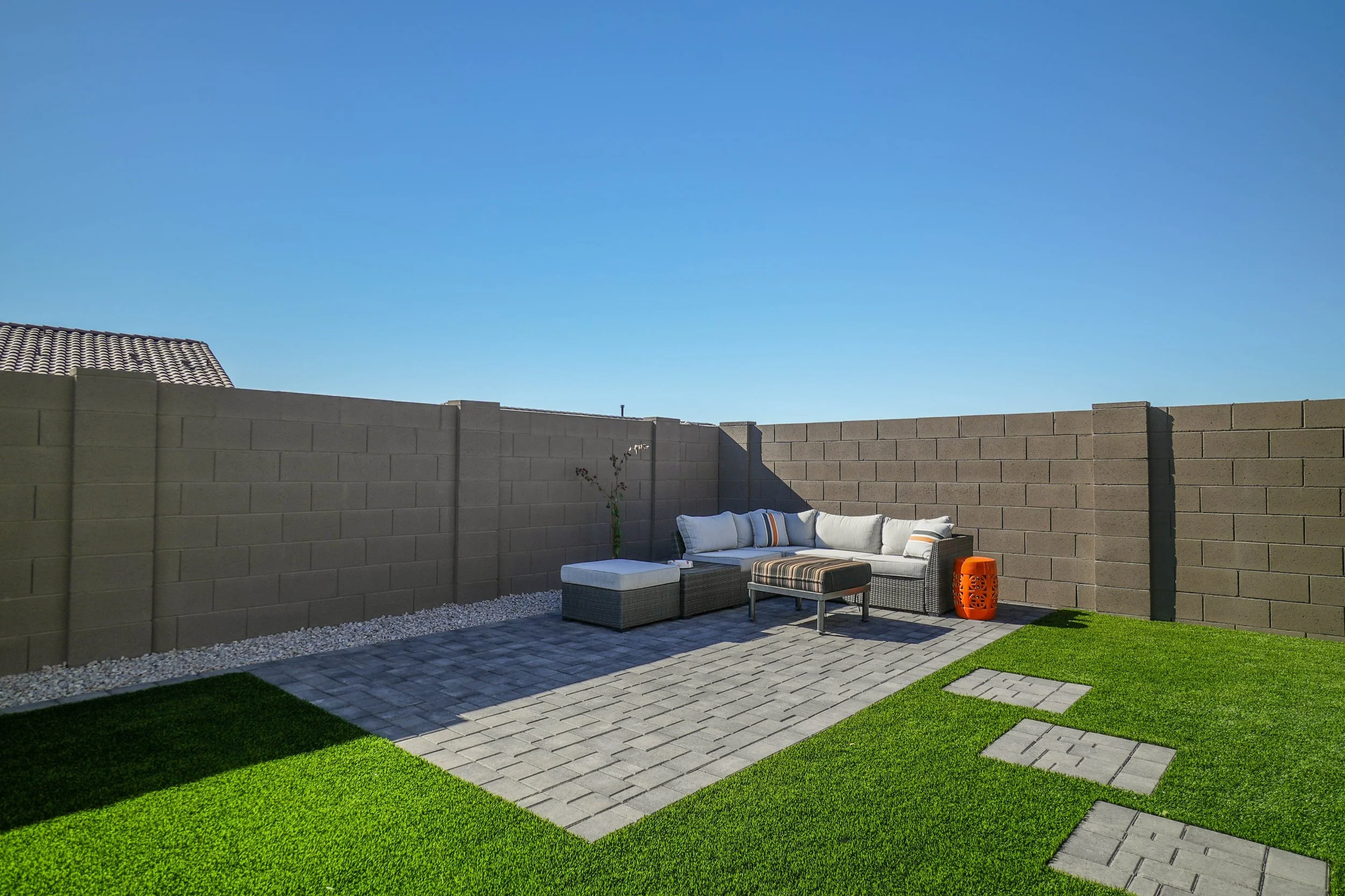 Residential backyard turf, pavers and rocks installed by Better Life Landscape and Design near Phoenix, Arizona.