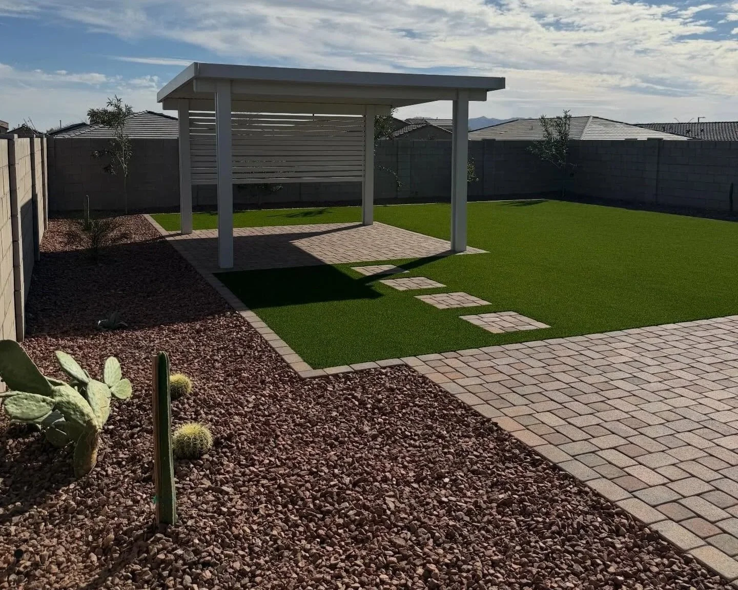 Backyard Pergola Installation along with turf, rocks, pavers and trees by Better Life Landscape and Design at this local home near the Phoenix area
