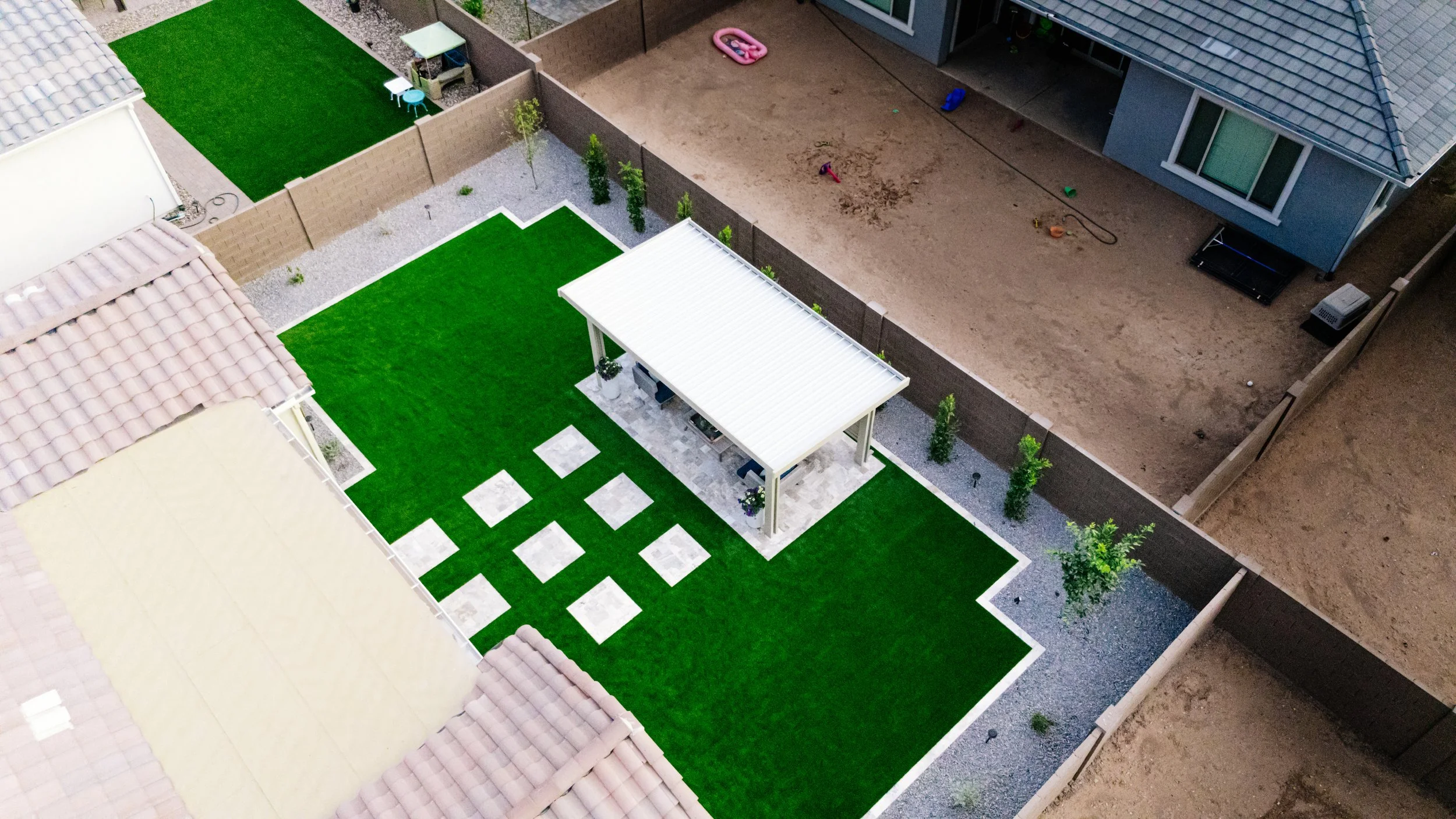 Pergola, tree, rocks, turf and travertine walkway installation by Better LIfe Landscape & Design near San Tan Valley, Arizona