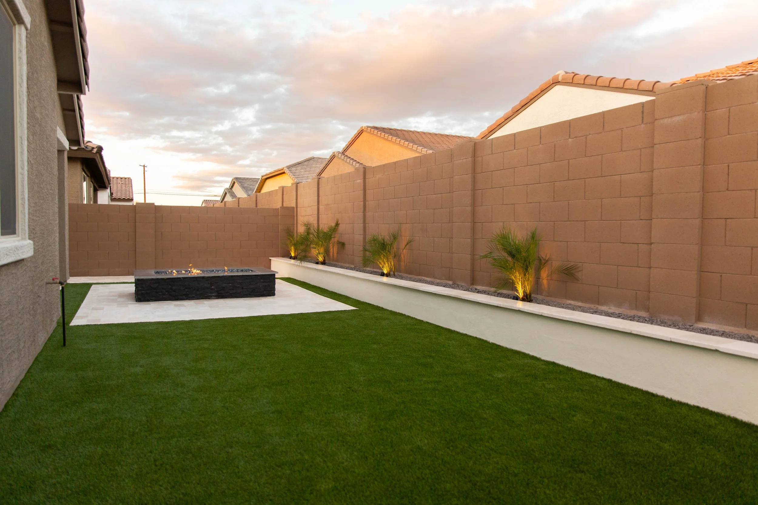 Lighting, tree, turf, travertine and custom built-in gas fire pit installation at a residential backyard.JPG