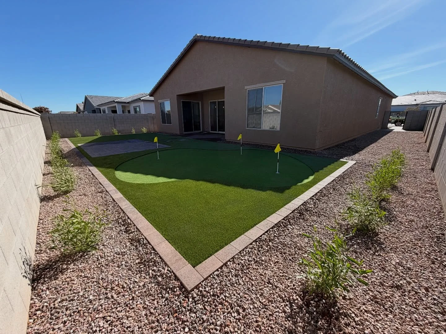 Turf putting green, tree, rocks and paver installation by Better Life Landscape & Design near Phoenix