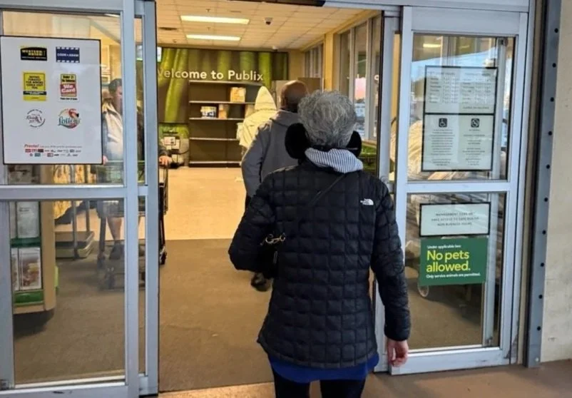 24 - We wandered over to a nearby Publix (grocery store) and saw this ear-muffed woman at the entrance butt ahead of us to escape the bitter cold.