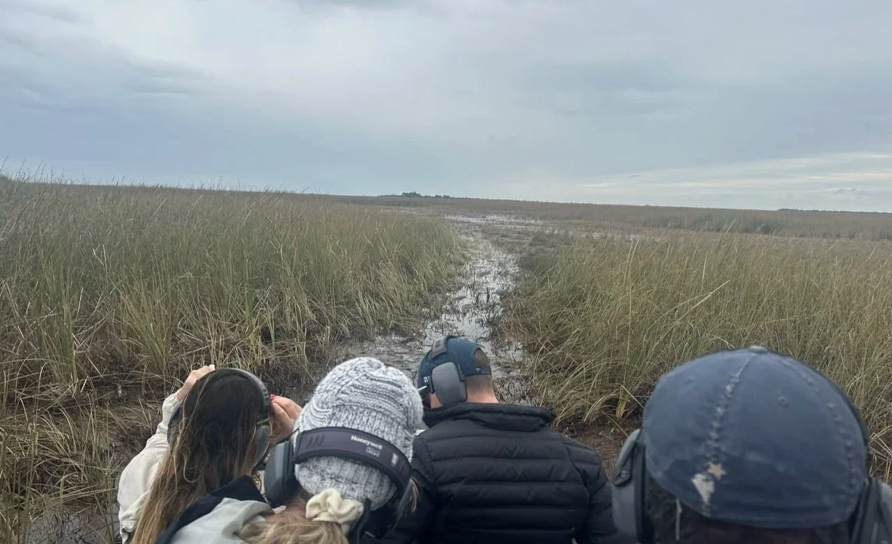 58 - And we're off!  Notice that everyone is wearing hearing protection. Our airboat had a very noisy, fully exposed V8 engine on the back.