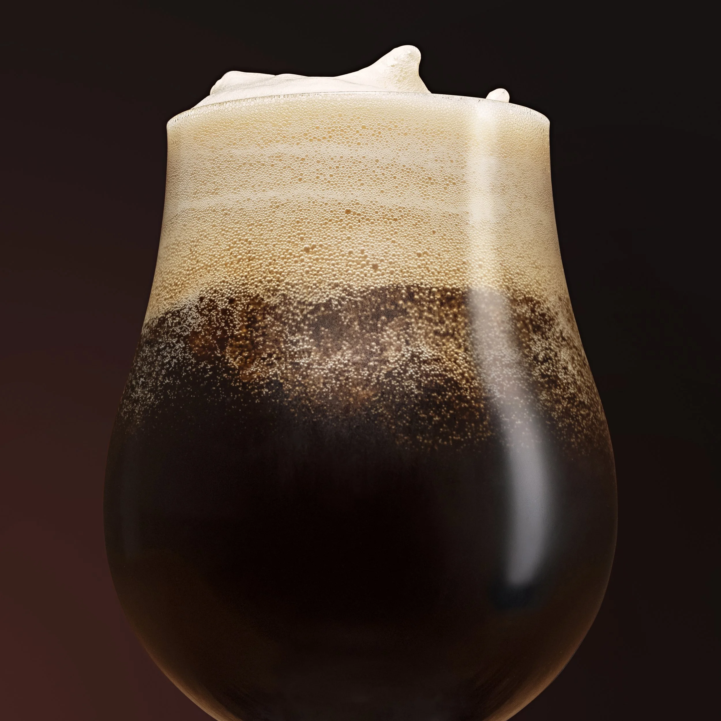 Close-up of a dark beer in a tulip glass with foam head