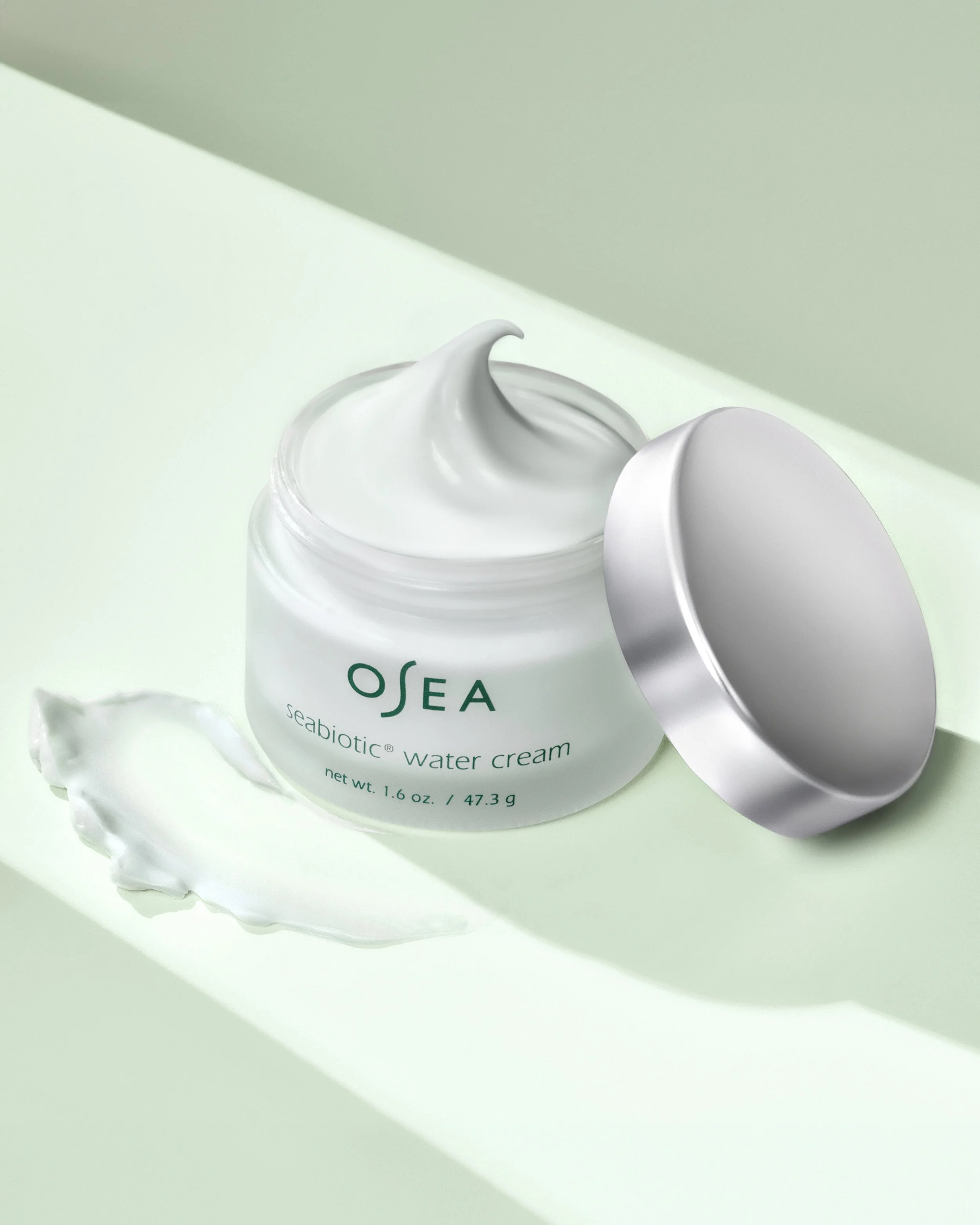 Green background Osea cream displayed by Juan Zabala product photography