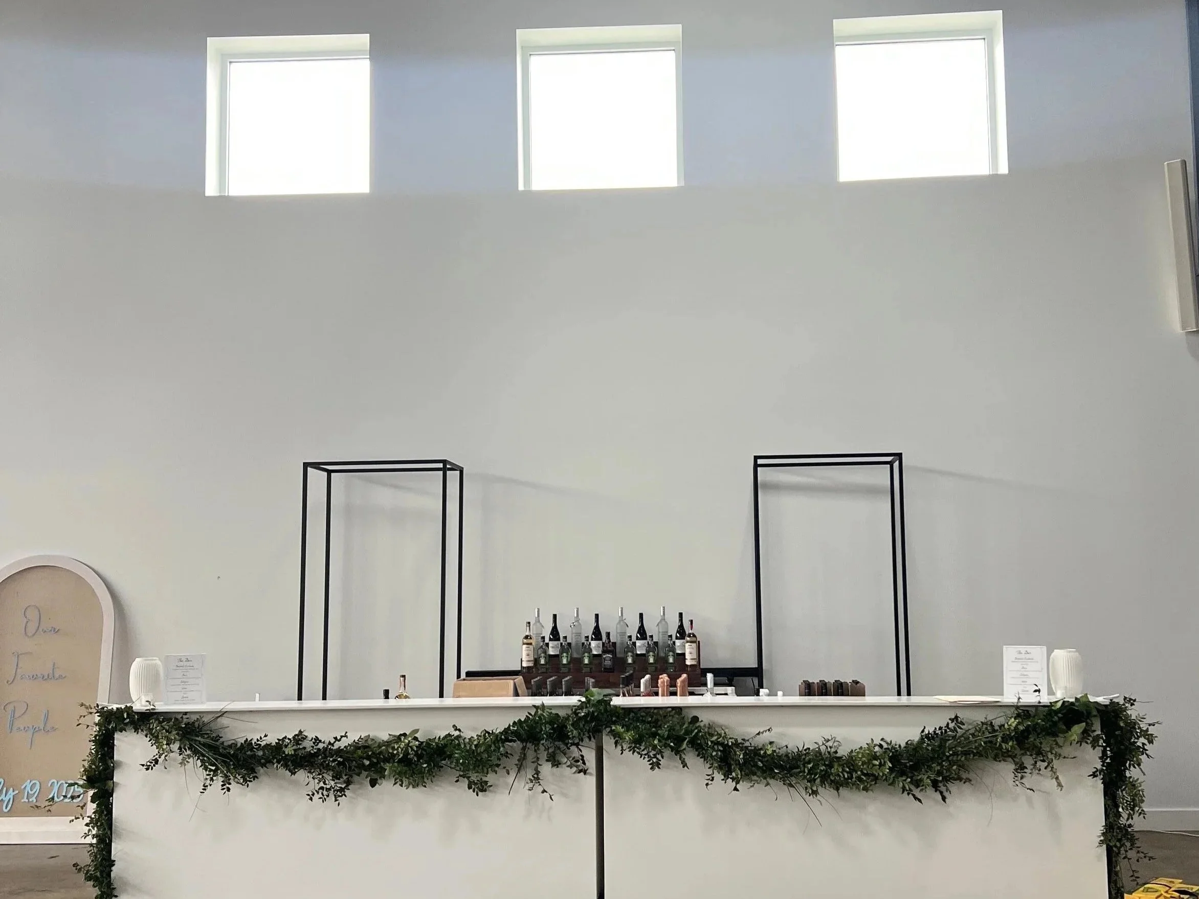 Two 8' White Bars with fresh greenery garland swag.