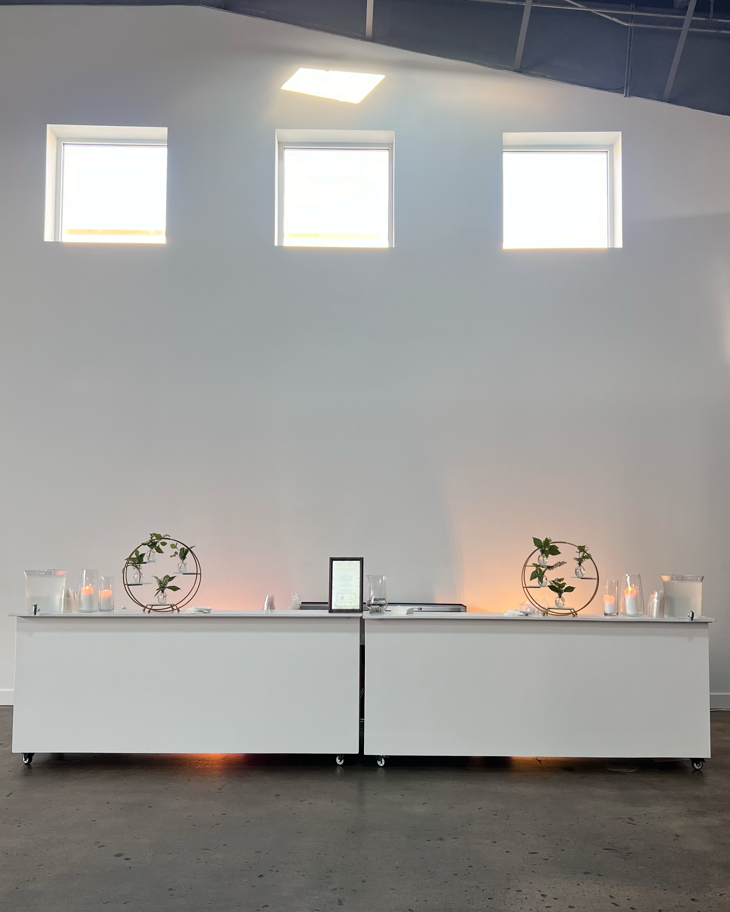 Simple uplighting on bar, white with gold display pieces for beverages.