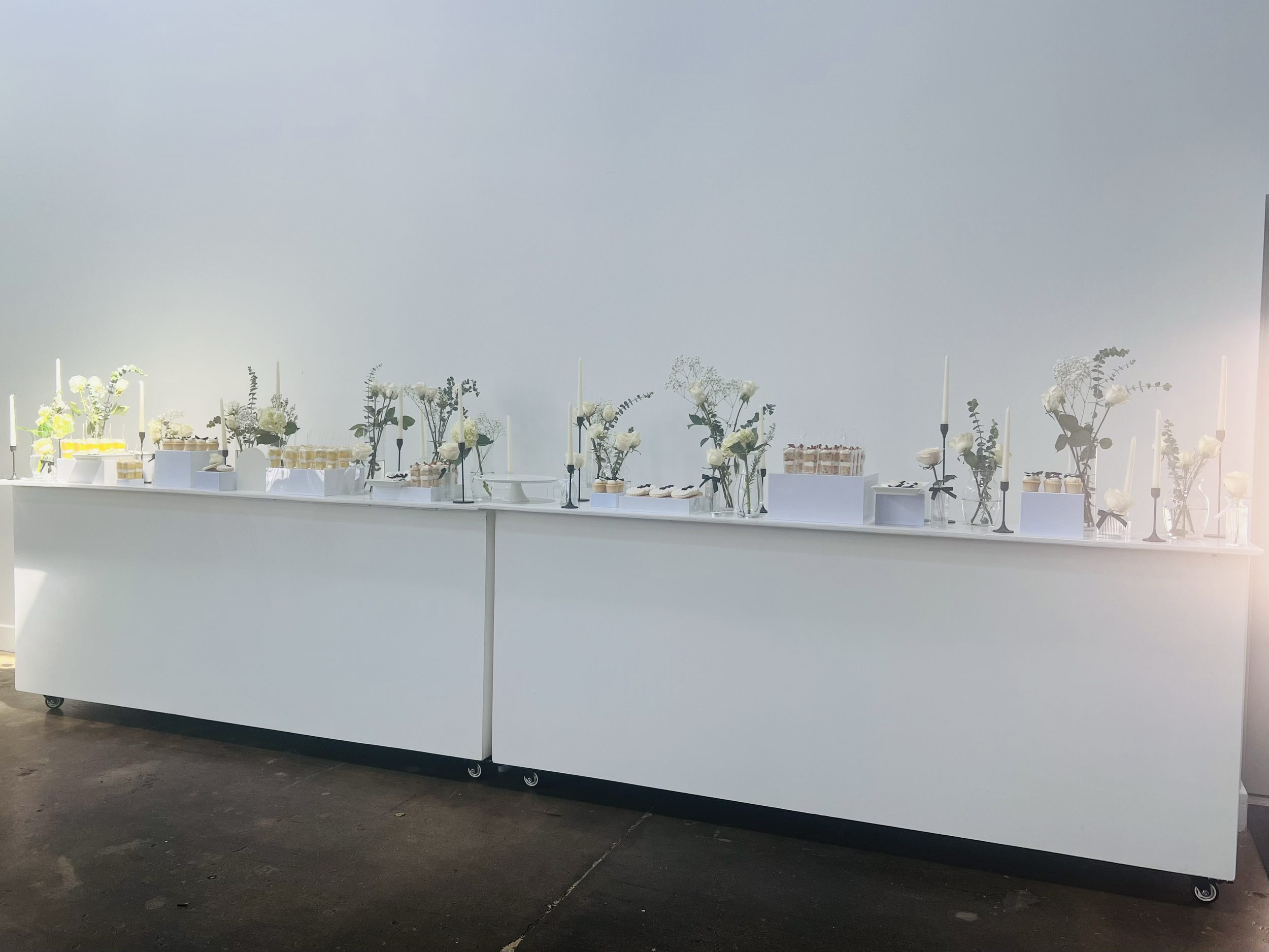 White bar with whimsical florals and used for desserts & cocktails.