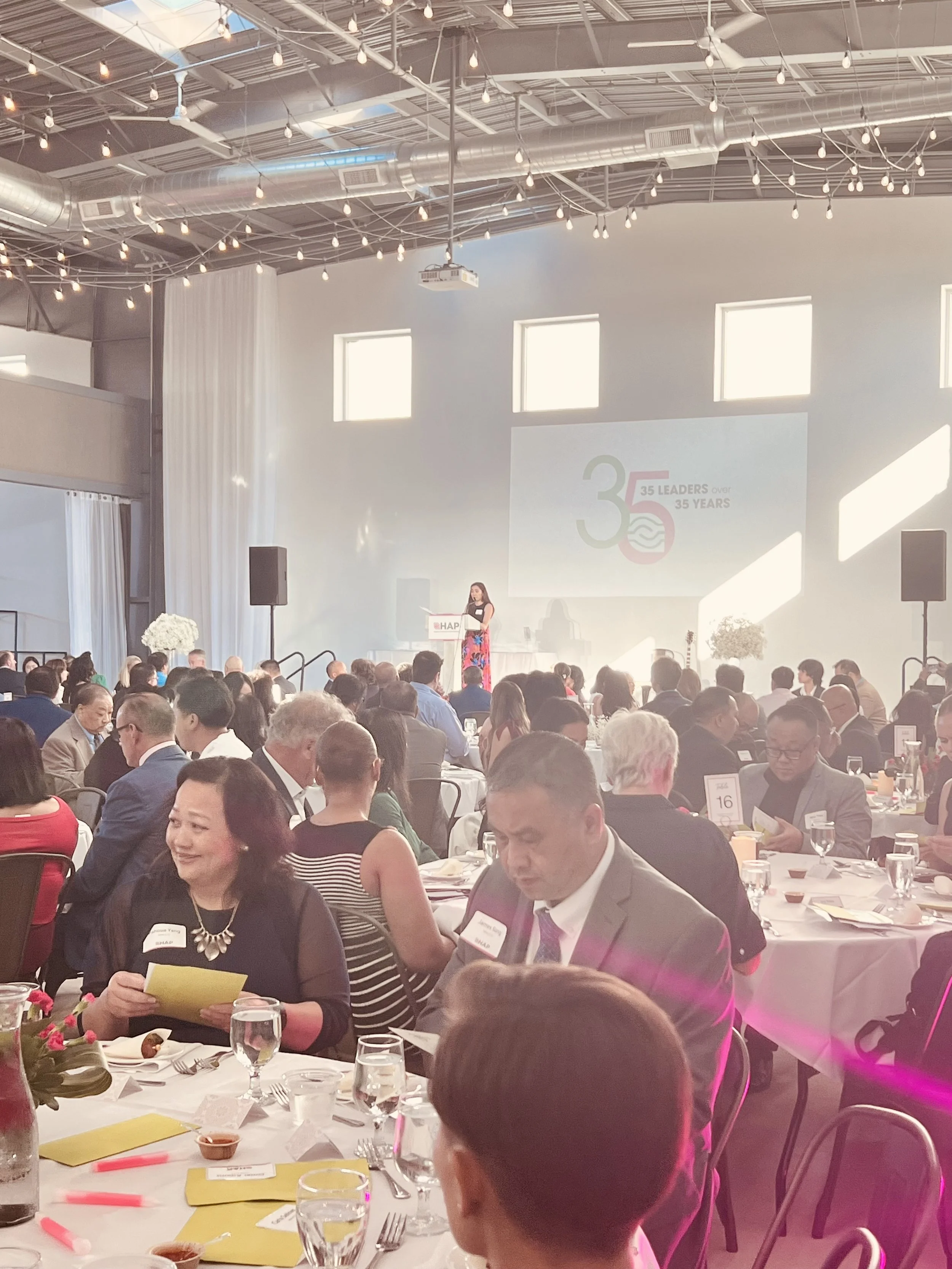 Banquet event with 300 guests at dinner tables watching a presentation.