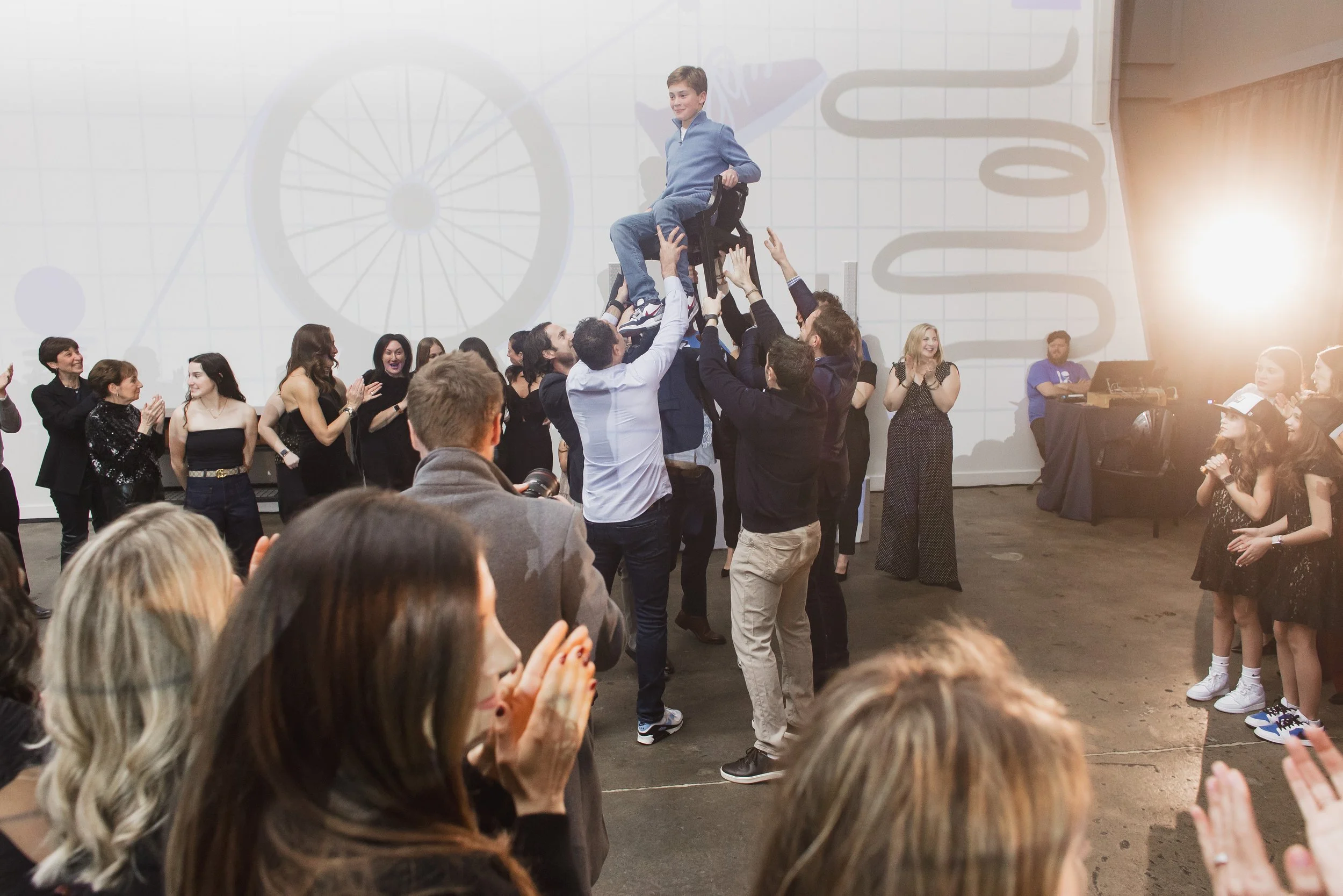 Bar Mitzvah celebration with horah (hora) dance, family and friend surrounding the guest of honor on the chair lift.