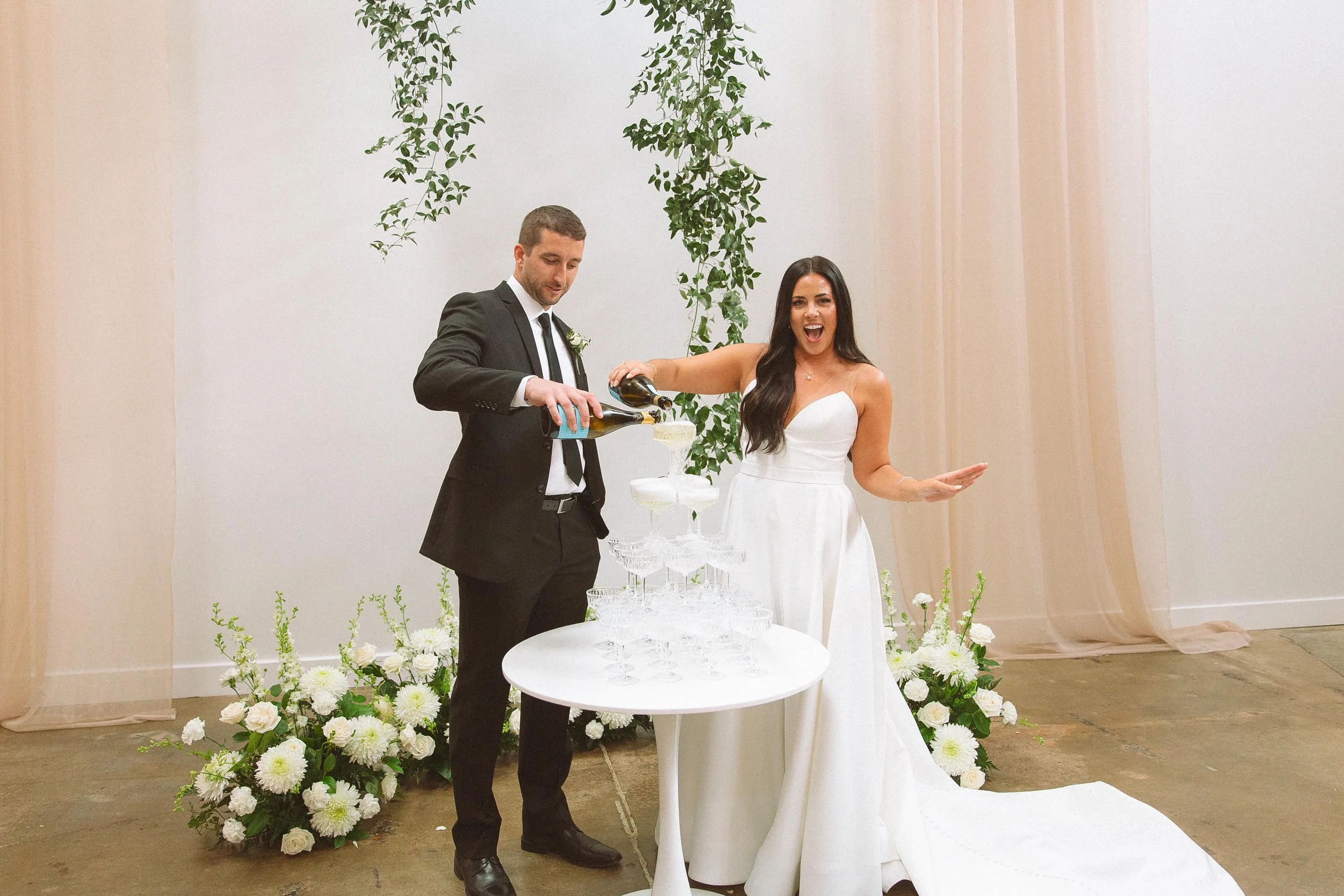 Bride and Groom celebrating their vows with a post-ceremony champagne tower for them and their wedding party!