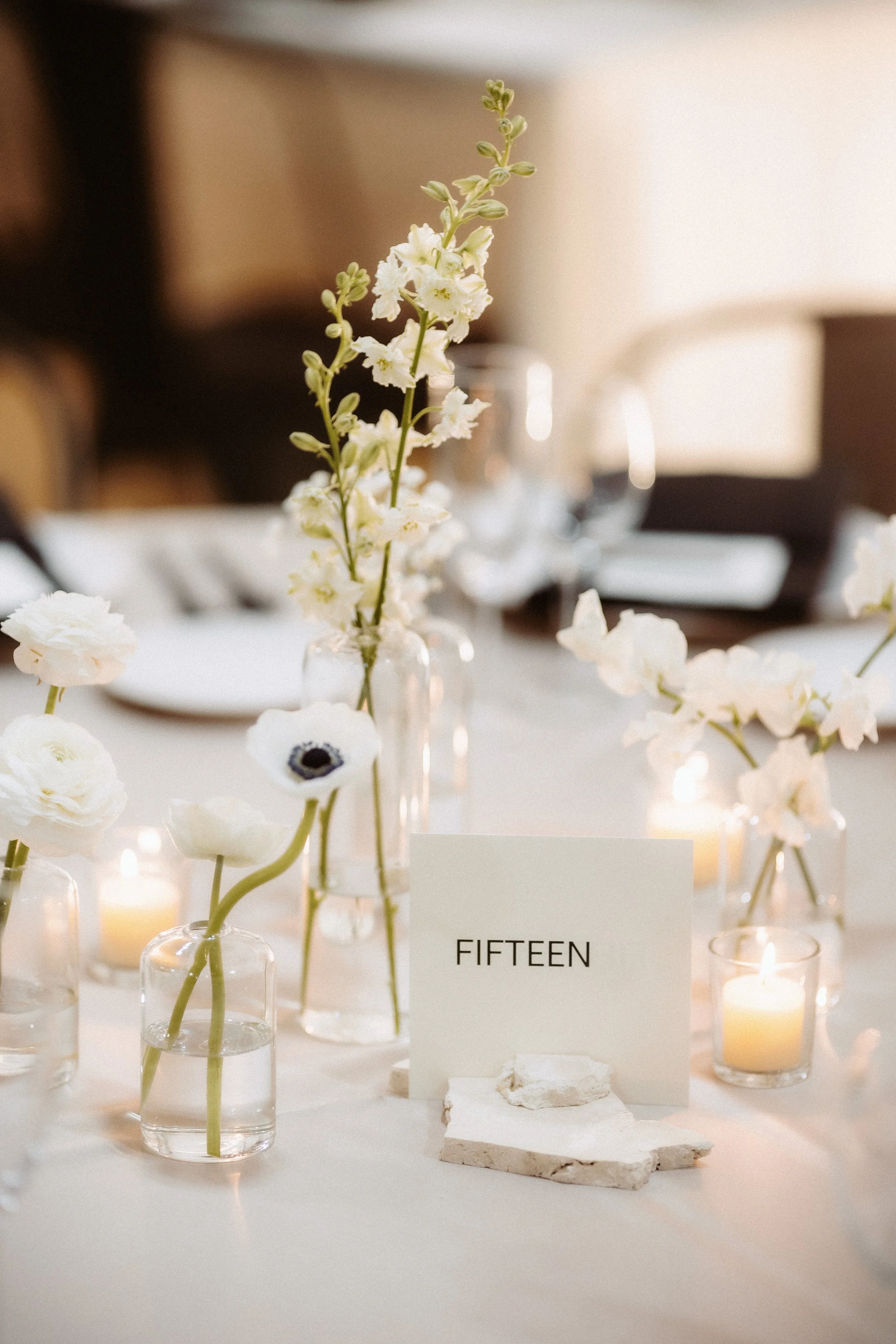 Close up image of modern white florals in bud vases for a simple, yet elegant table design.