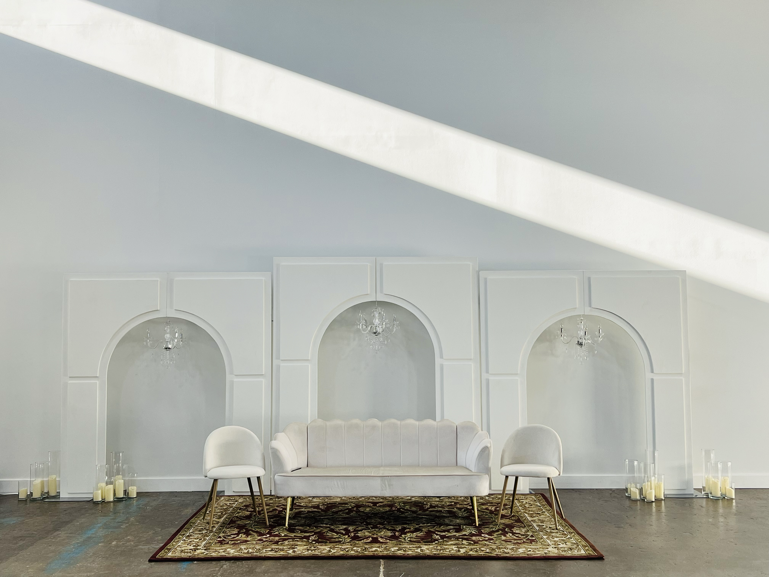 Simple Nikkah ceremony backdrop with colorful rug, gold accents and arch backdrop.