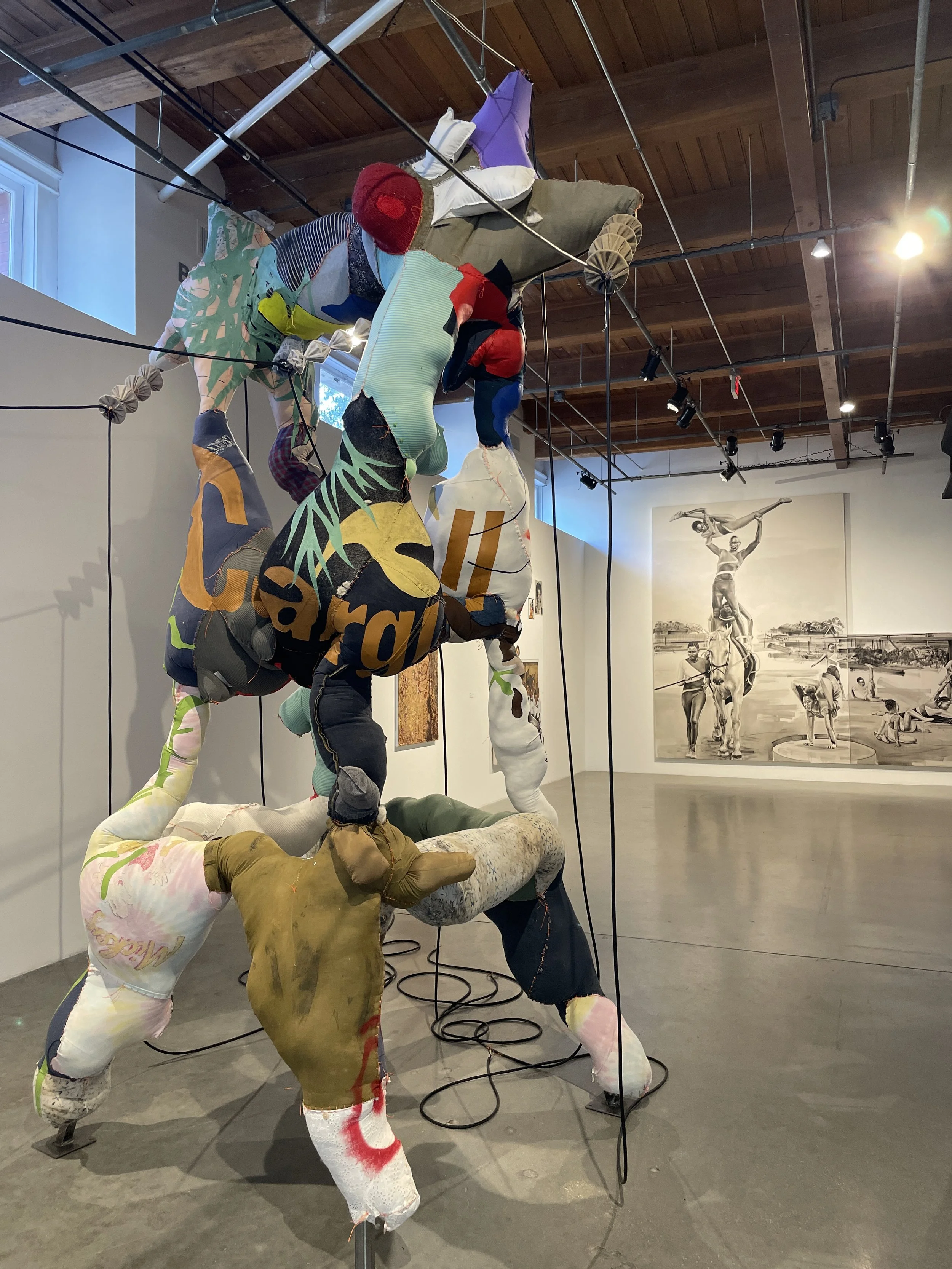 Eddie Rodolfo Aparicio 

Muñecas de transmisión (Bridge City/Whitnall Hwy) (Orange), 2024
Families' clothes, Ceiba tree fibers, thread, and paint on metal frame
