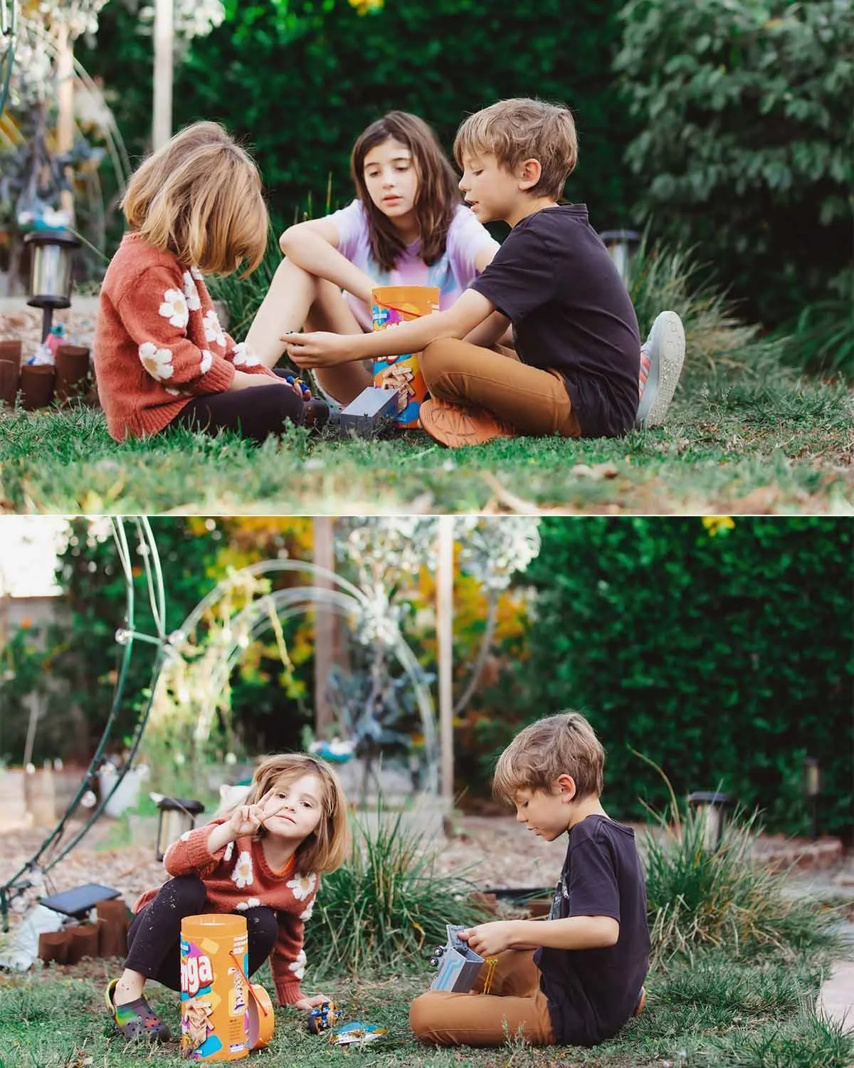 Three children, two girls and one boy, sitting on the grass in a backyard, playing with toys and a snack container. In the background, a garden with plants, garden tools, and decorations.
