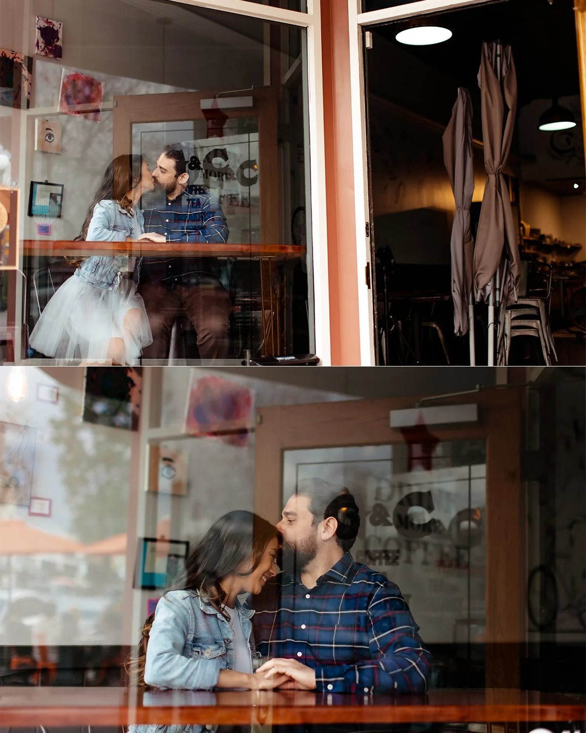A couple sharing a kiss through a window, with the woman sitting on the man's lap at a table inside a cafe.