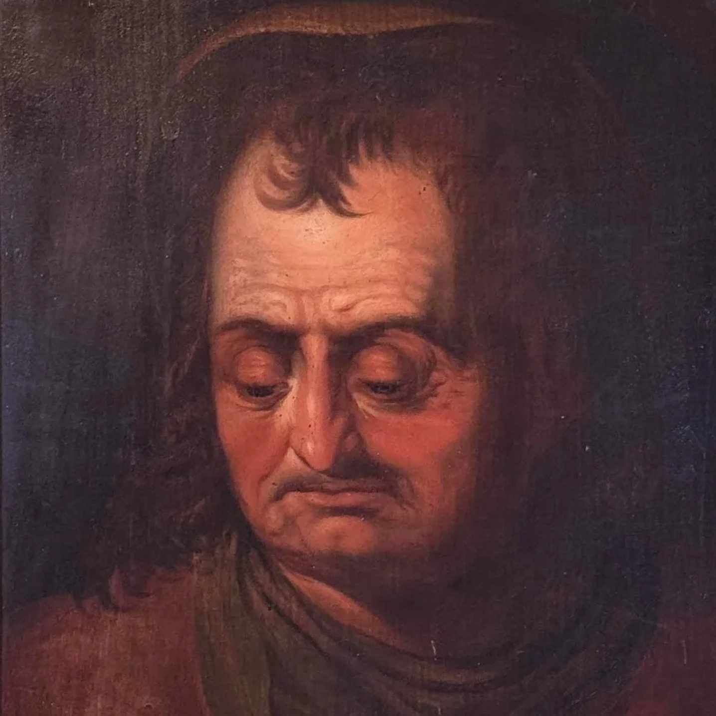 A portrait of a man with long hair, furrowed brows, and a downward-turned mouth, looking downward with a somber expression.