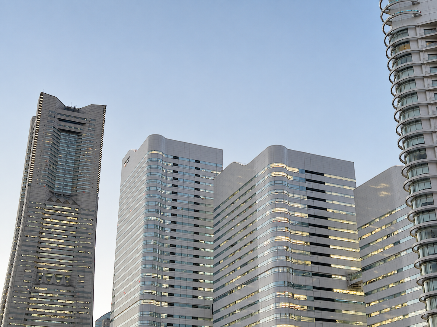 Skyscrapers in a city during dusk or early evening with a clear sky.