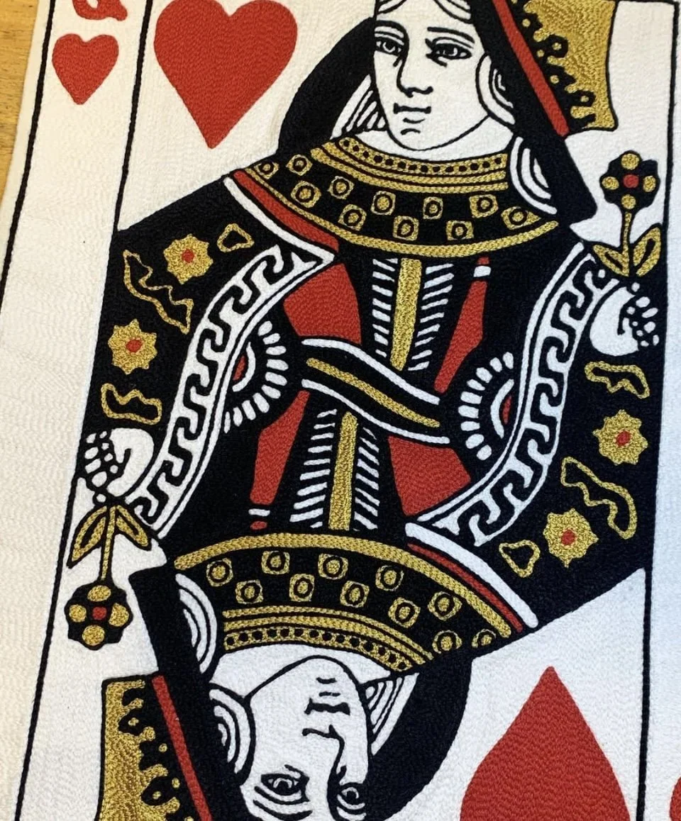 Close-up image of the Queen of Hearts playing card showing the face and upper body of the queen with detailed black, red, white, and gold design elements.