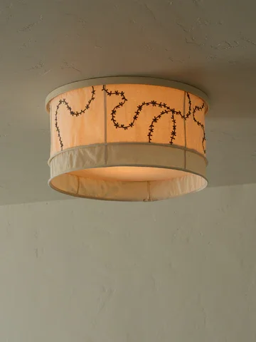 Warm-colored ceiling light fixture with decorative string lights pattern.
