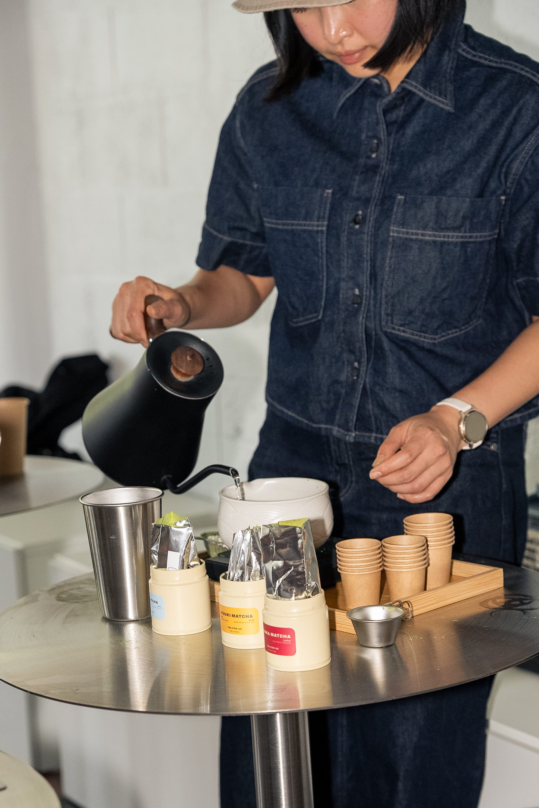 Flash photo of brand owner pouring hot water into matcha during a Tea For Us brand activation pop-up with Kindred Studio in San Francisco