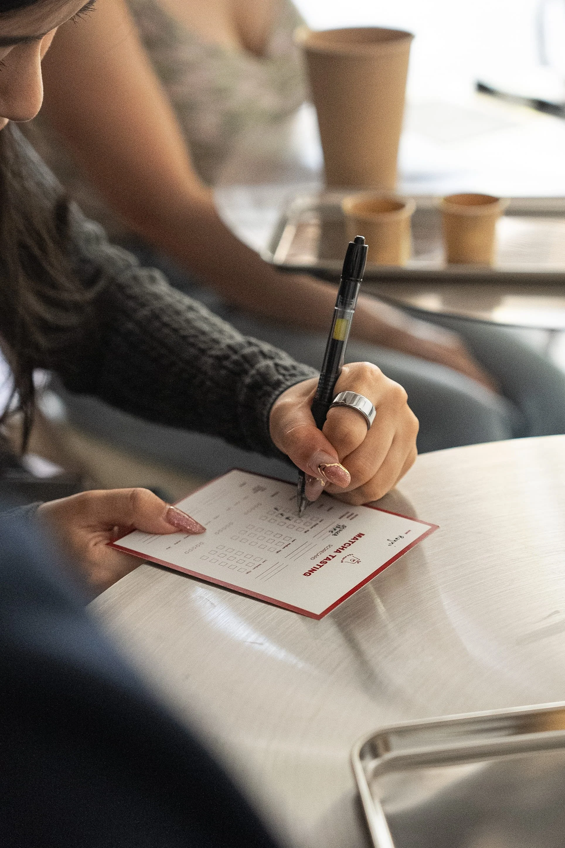 Close up shot of a customer filling out the matcha tasting flavor profile form during a Tea For Us brand activation pop-up with Kindred Studio in San Francisco