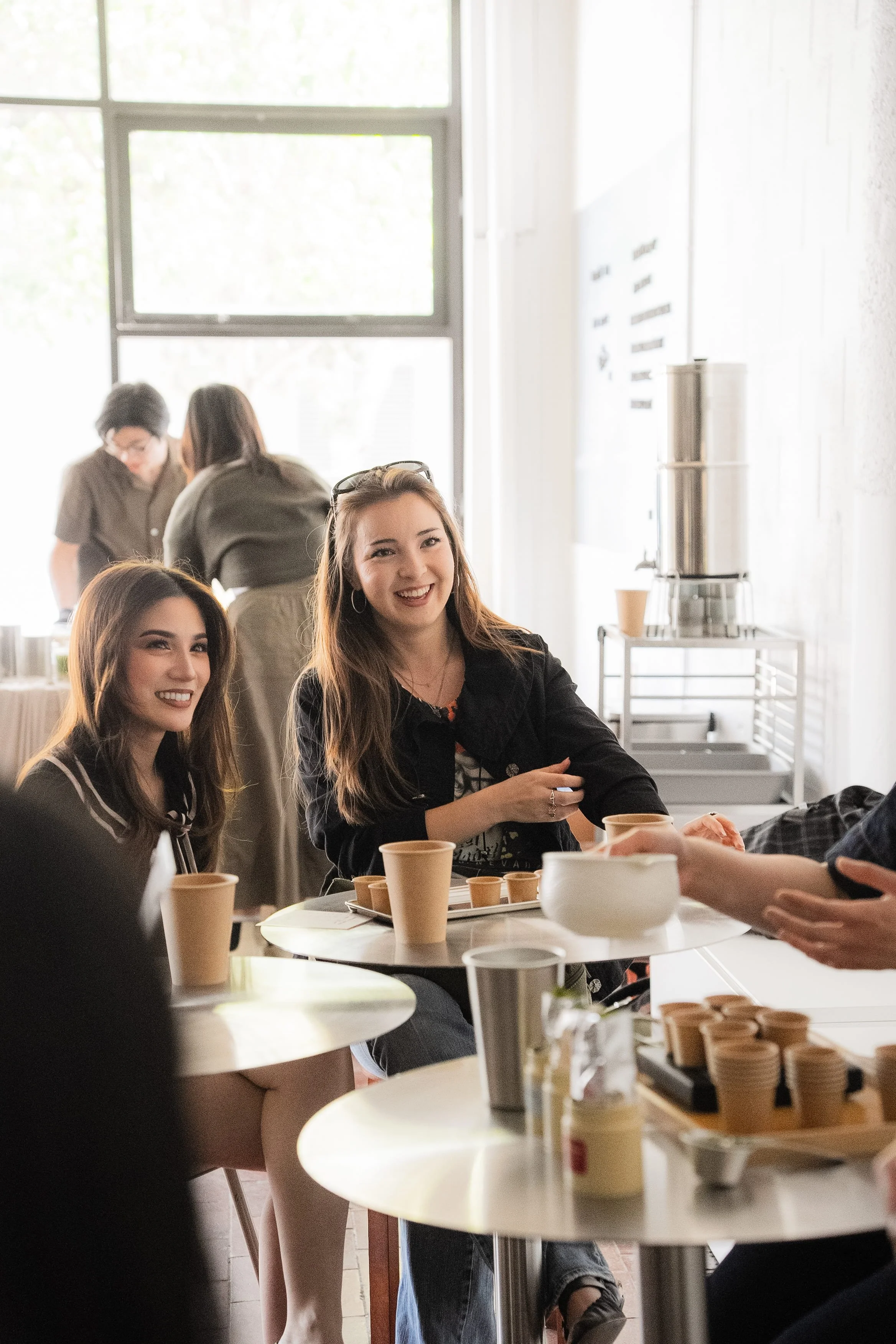 Candid photo of customers smiling while tasting matcha during a Tea For Us brand activation pop-up with Kindred Studio in San Francisco