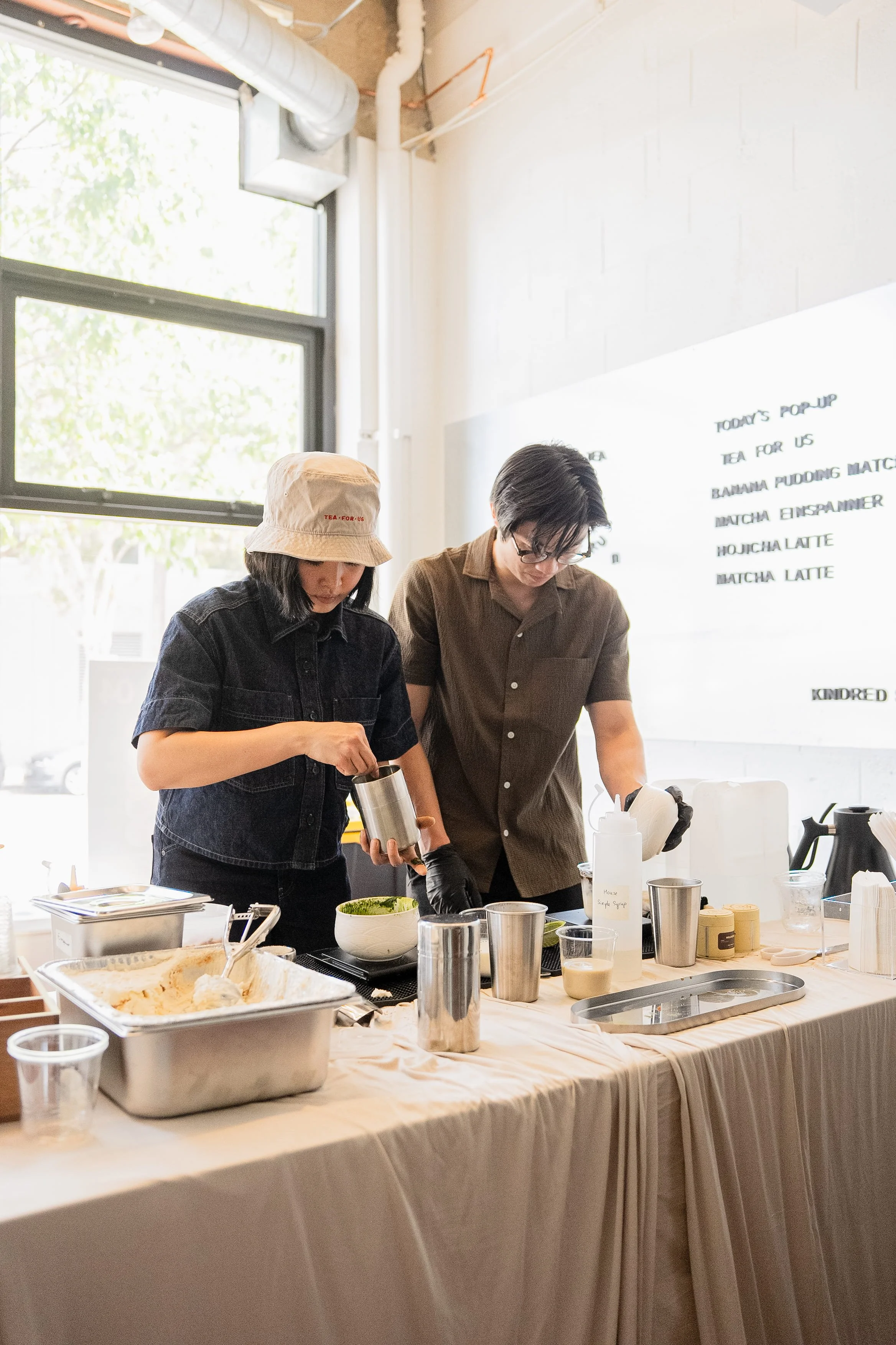 Action shot of staff making matcha drinks during a Tea For Us brand activation pop-up with Kindred Studio in San Francisco