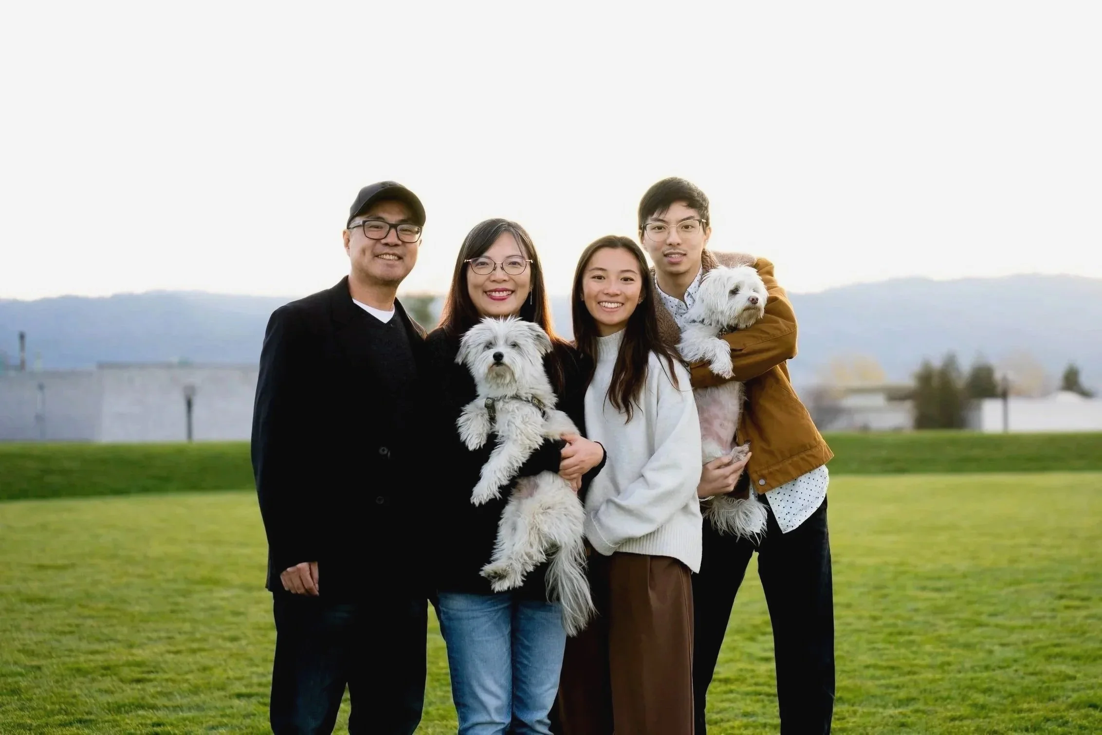 Asian family portrait during sunset at a San Francisco Bay Area park,  featuring two small white dogs