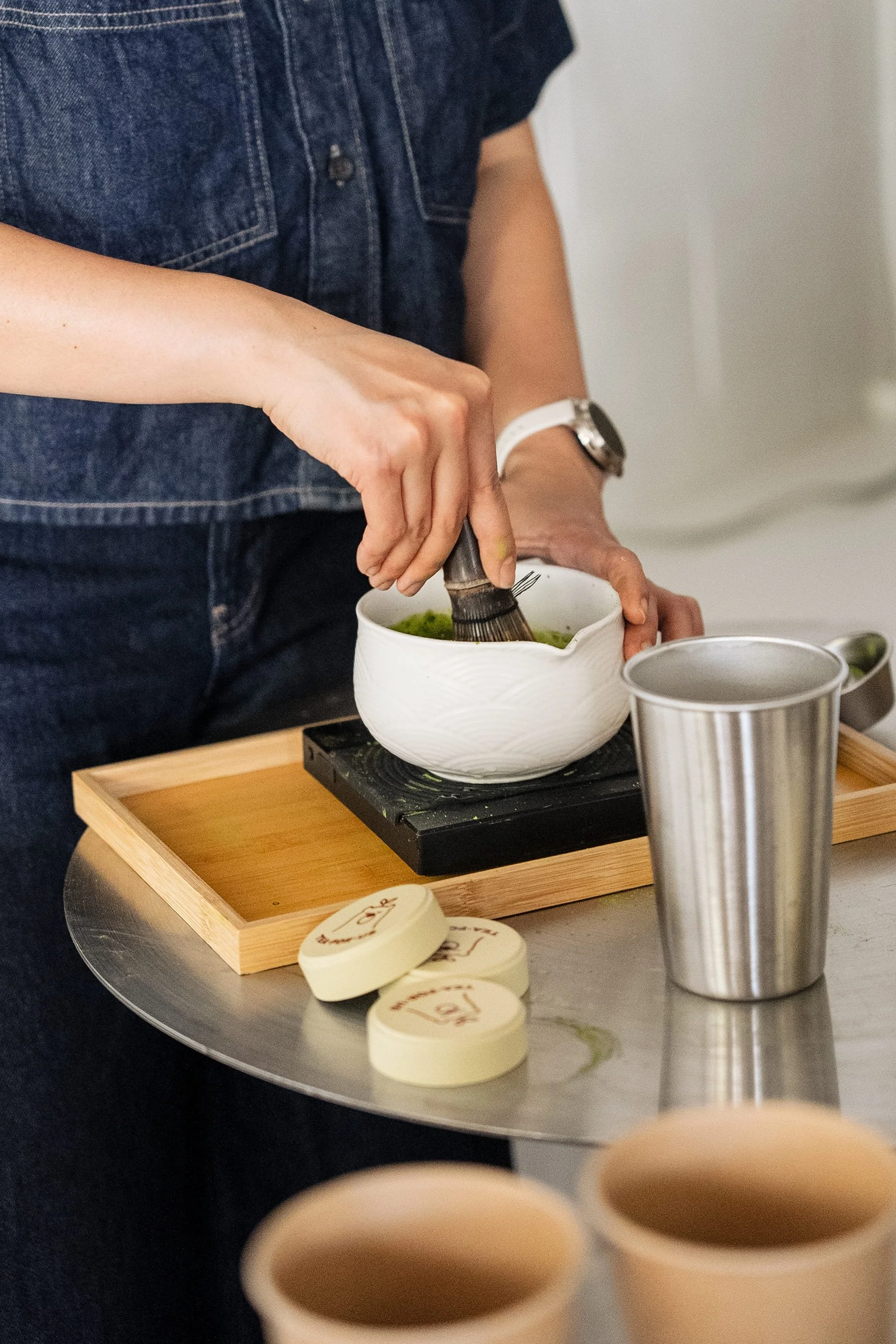 Close up action shot of brand owner whisking matcha during a Tea For Us brand activation pop-up with Kindred Studio in San Francisco