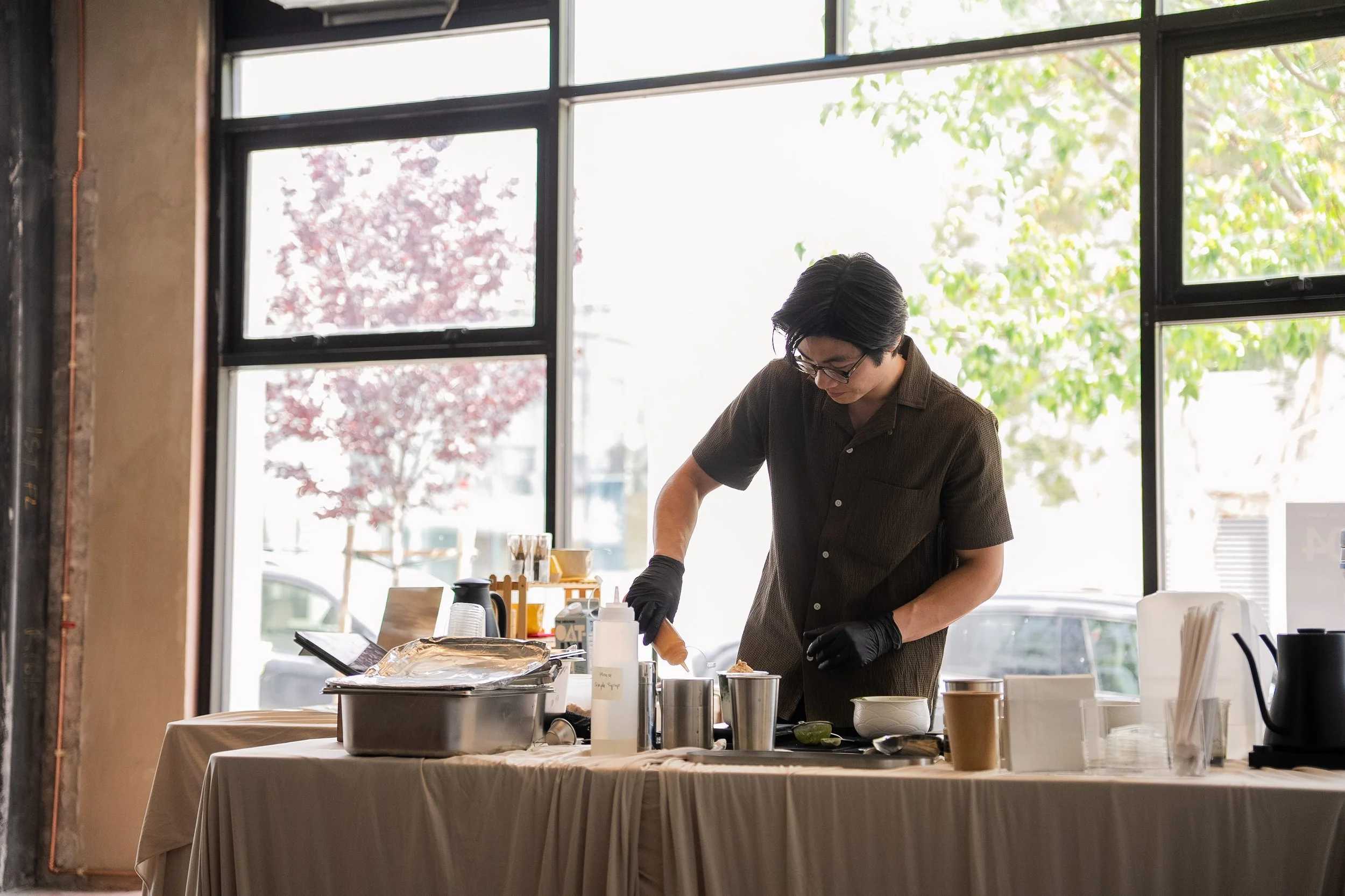 Action shot of barista making matcha drinks during a Tea For Us brand activation pop-up with Kindred Studio in San Francisco