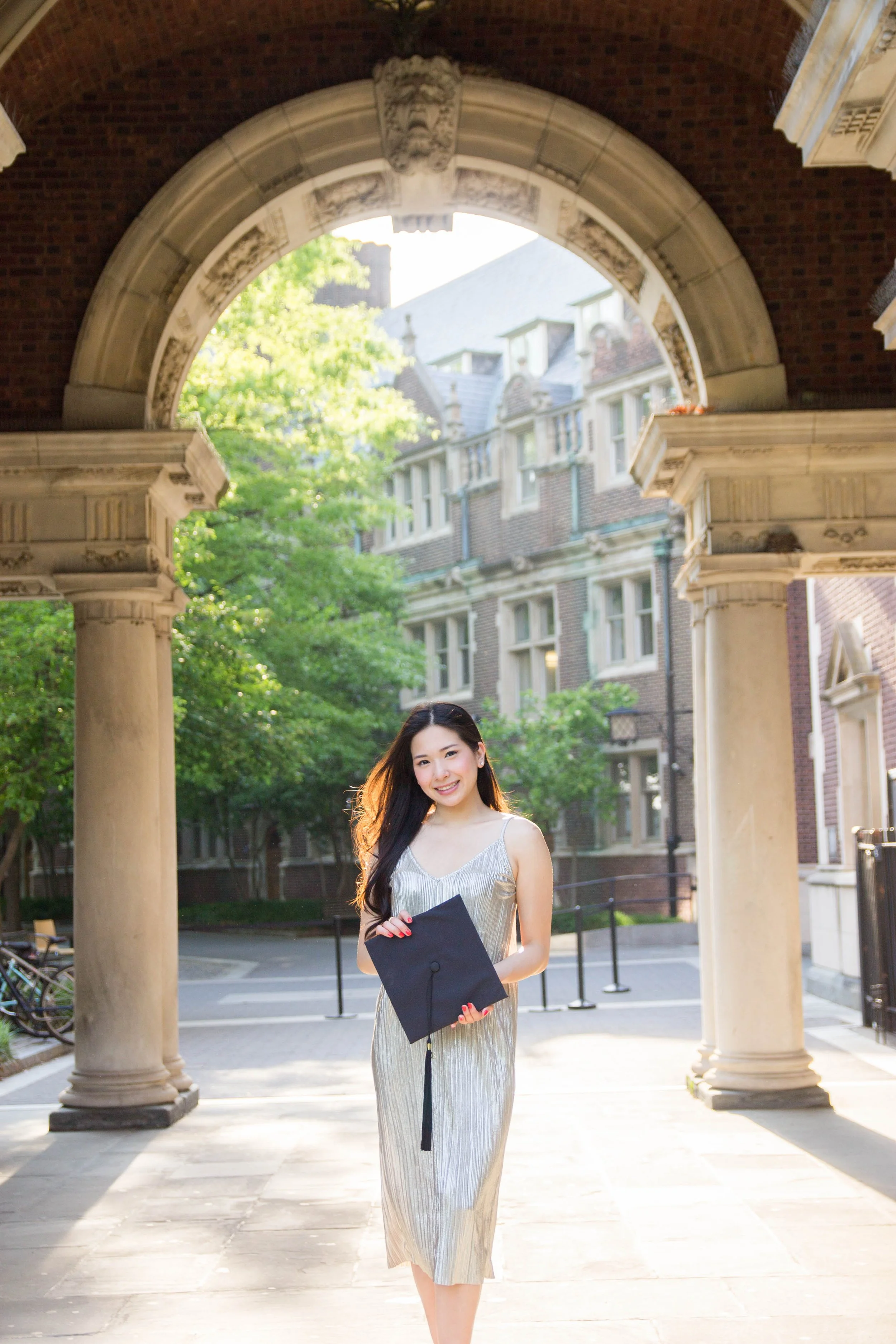 Senior college portrait of a woman holding a graduation cap at University of Pennsylvania