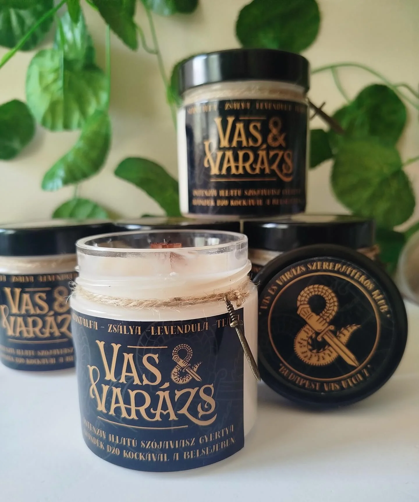 Meg&eacute;rkezett az első Vas &amp; Var&aacute;zs merch, h&aacute;rmas &ouml;sszefog&aacute;sban! A @nana_knight_artist &aacute;ltal k&eacute;sz&iacute;tett illatgyertya meglepet&eacute;s @wolfandpoppy_resinart d20-at rejt a m&eacute;ly&eacute;n!

A